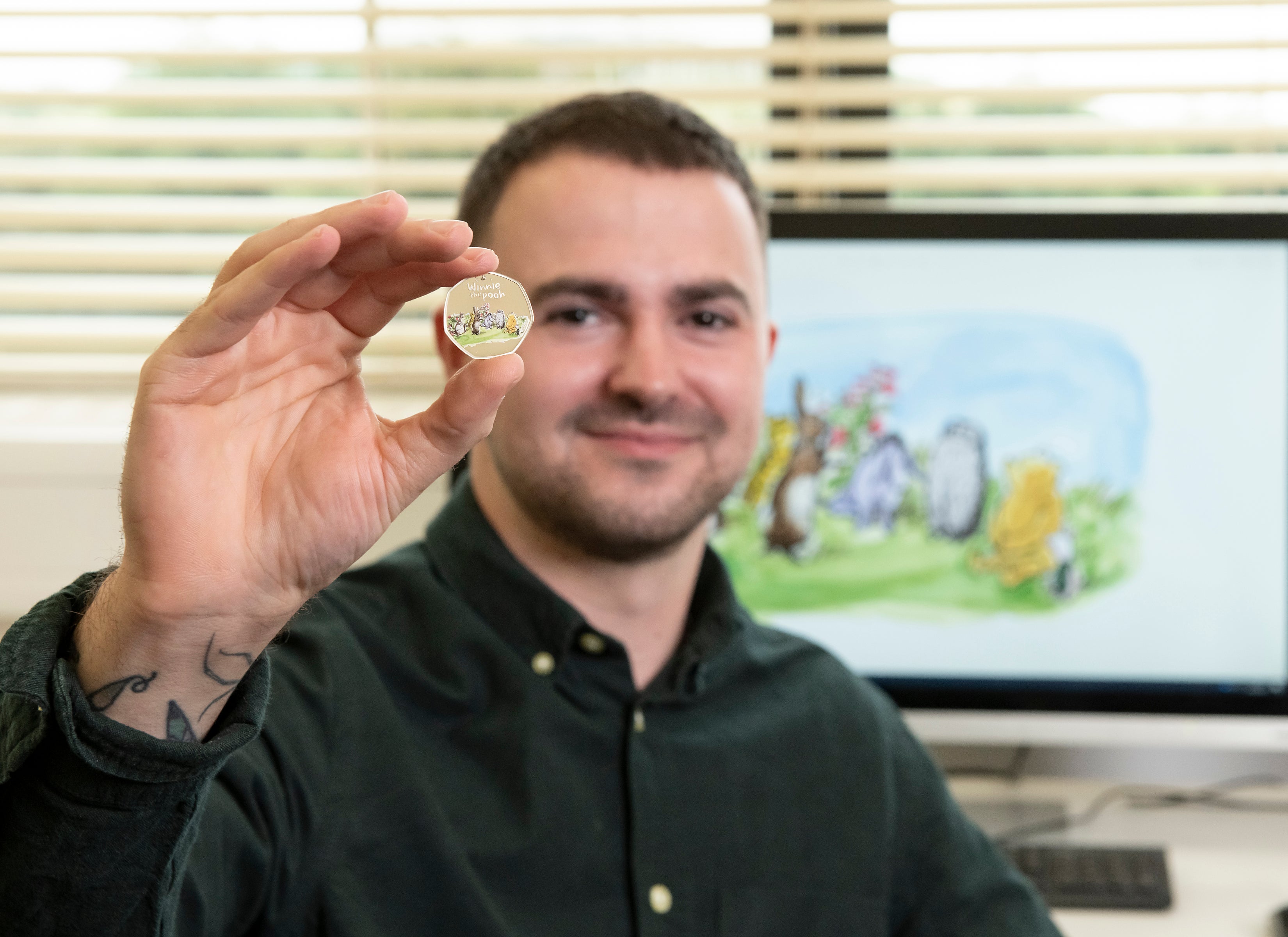 Royal Mint designer Daniel Thorne with the new Winnie-the-Pooh and Friends 50p coin (Royal Mint/PA)