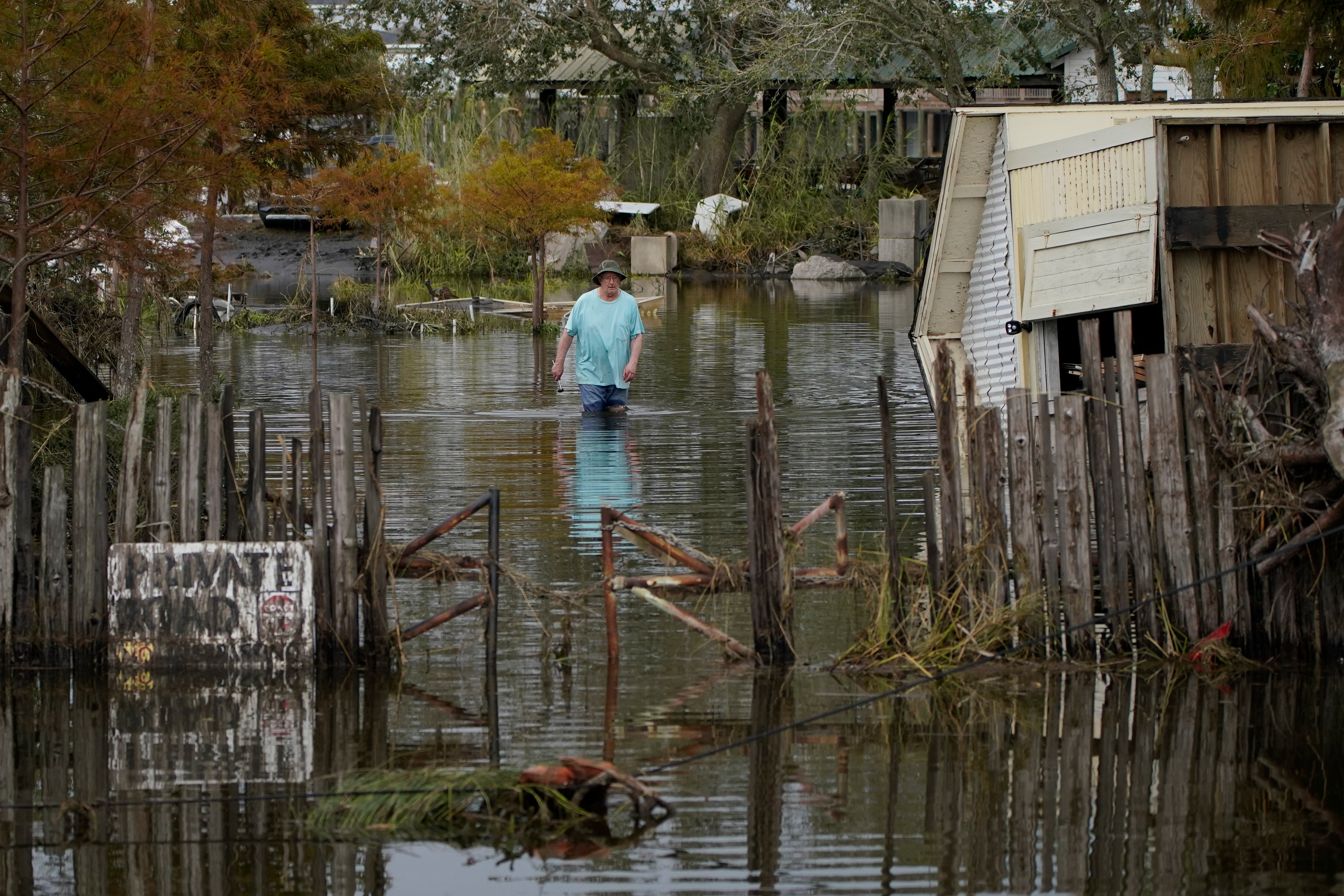 A man walks down a flooded street in the aftermath of storm Ida, on Wednesday, in Lafitte, Louisiana