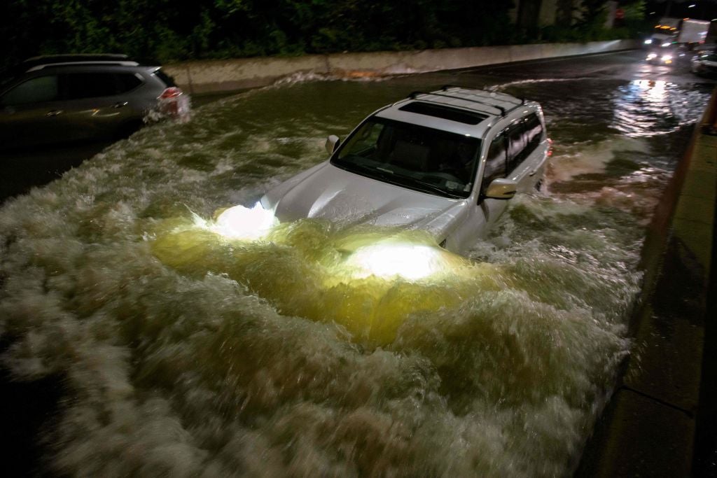 A motorist drives a car through a flooded expressway in Brooklyn, New York early on 2 September