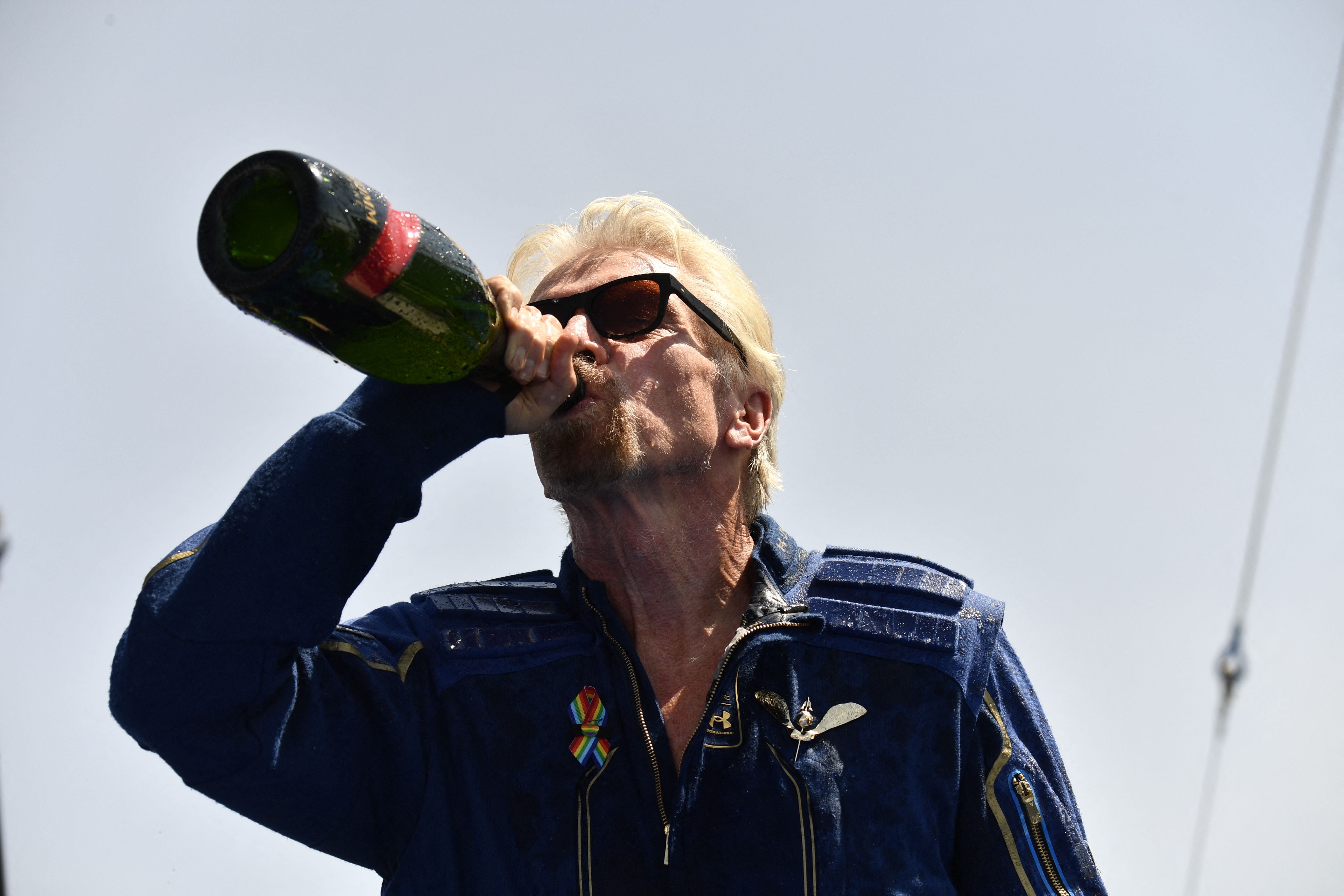 Virgin Galactic founder Sir Richard Branson, drinks champagne with crew members after flying into space aboard a Virgin Galactic vessel, a voyage he described as the "experience of a lifetime" -- and one he hopes will usher in an era of lucrative space tourism. Spaceport America, near Truth and Consequences, New Mexico on July 11, 2021