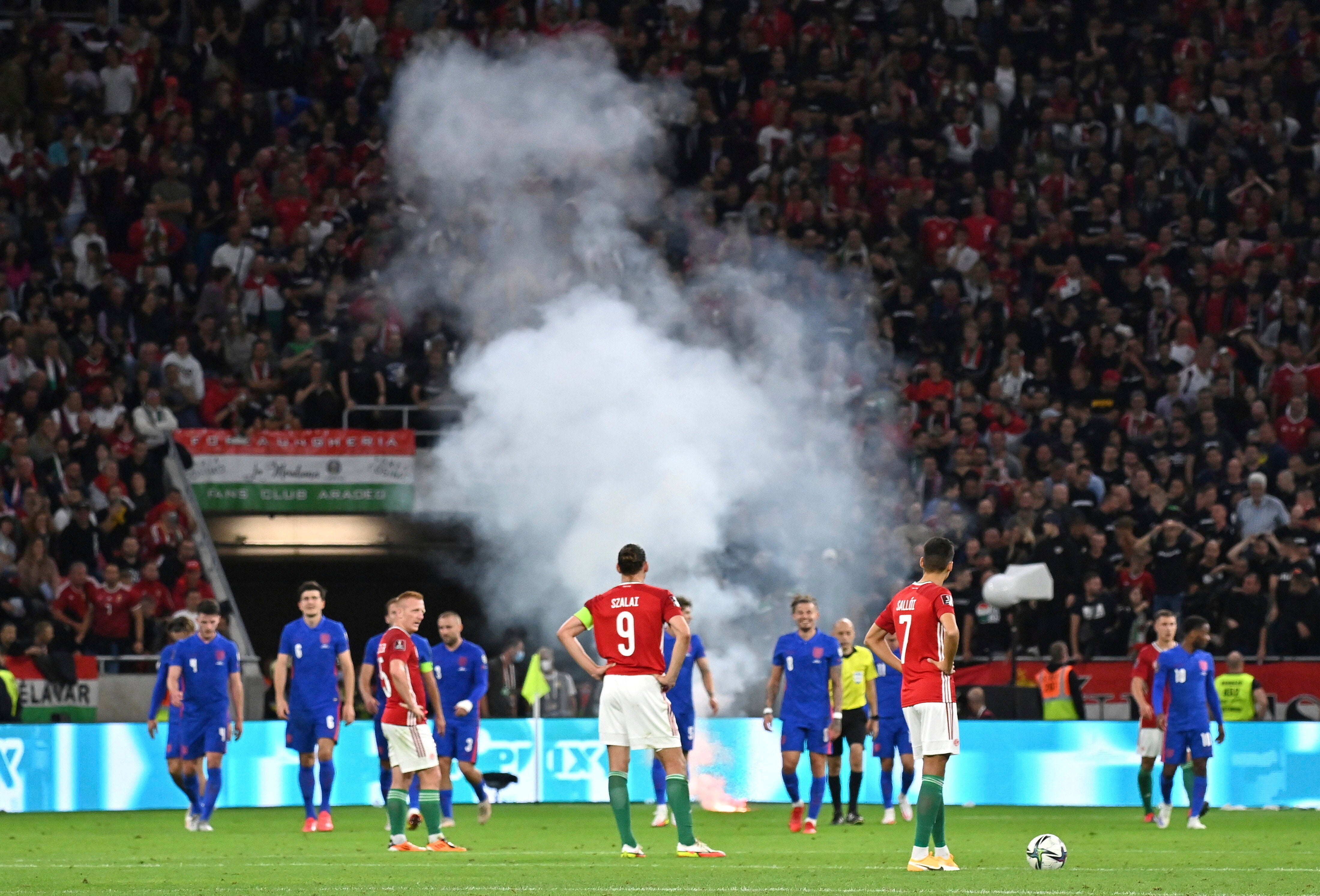 Players wait after a flare was thrown on to the pitch following England’s third goal (Tibor Illyes/AP).