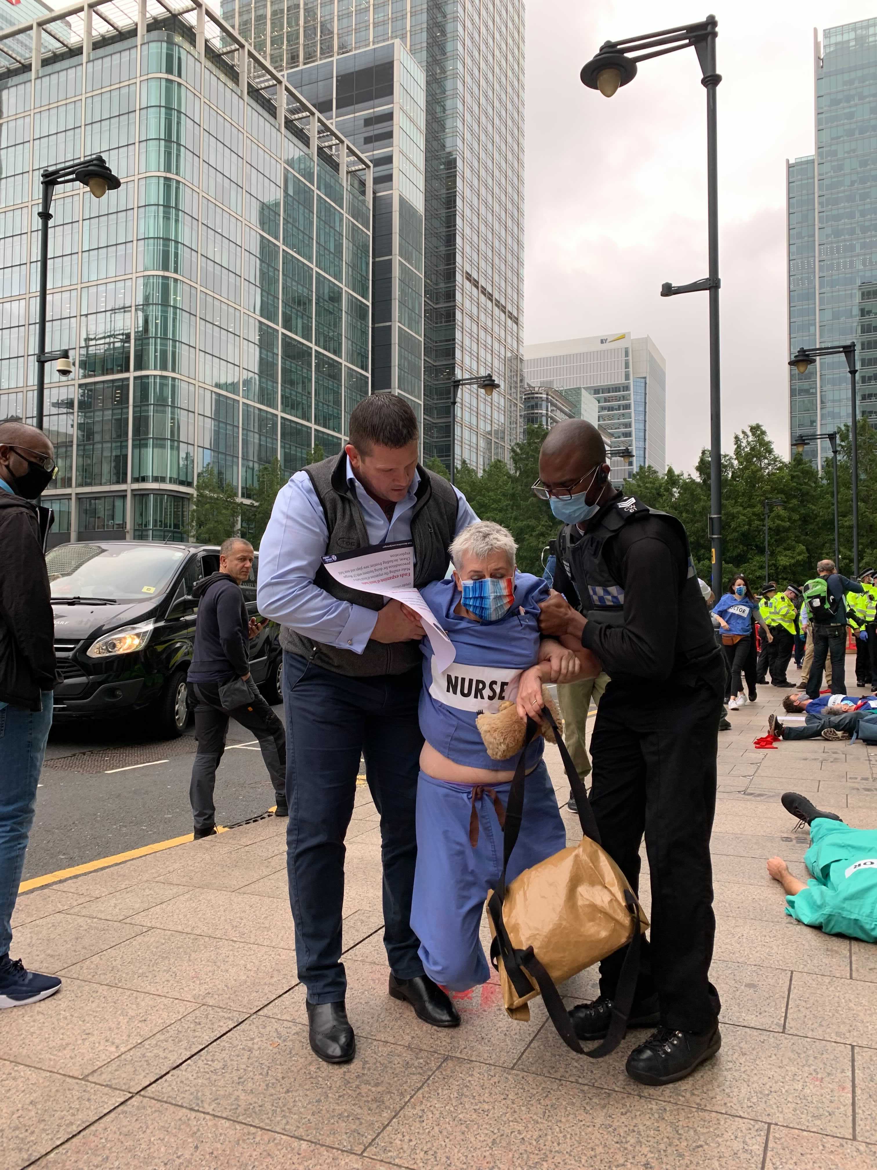 This woman dressed in nursing scrubs was led away by security