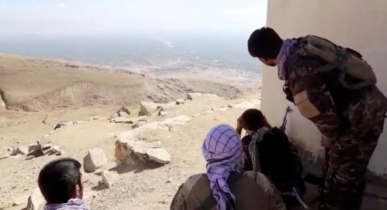 Members of National Resistance Front observe by a house near Panjshir Valley