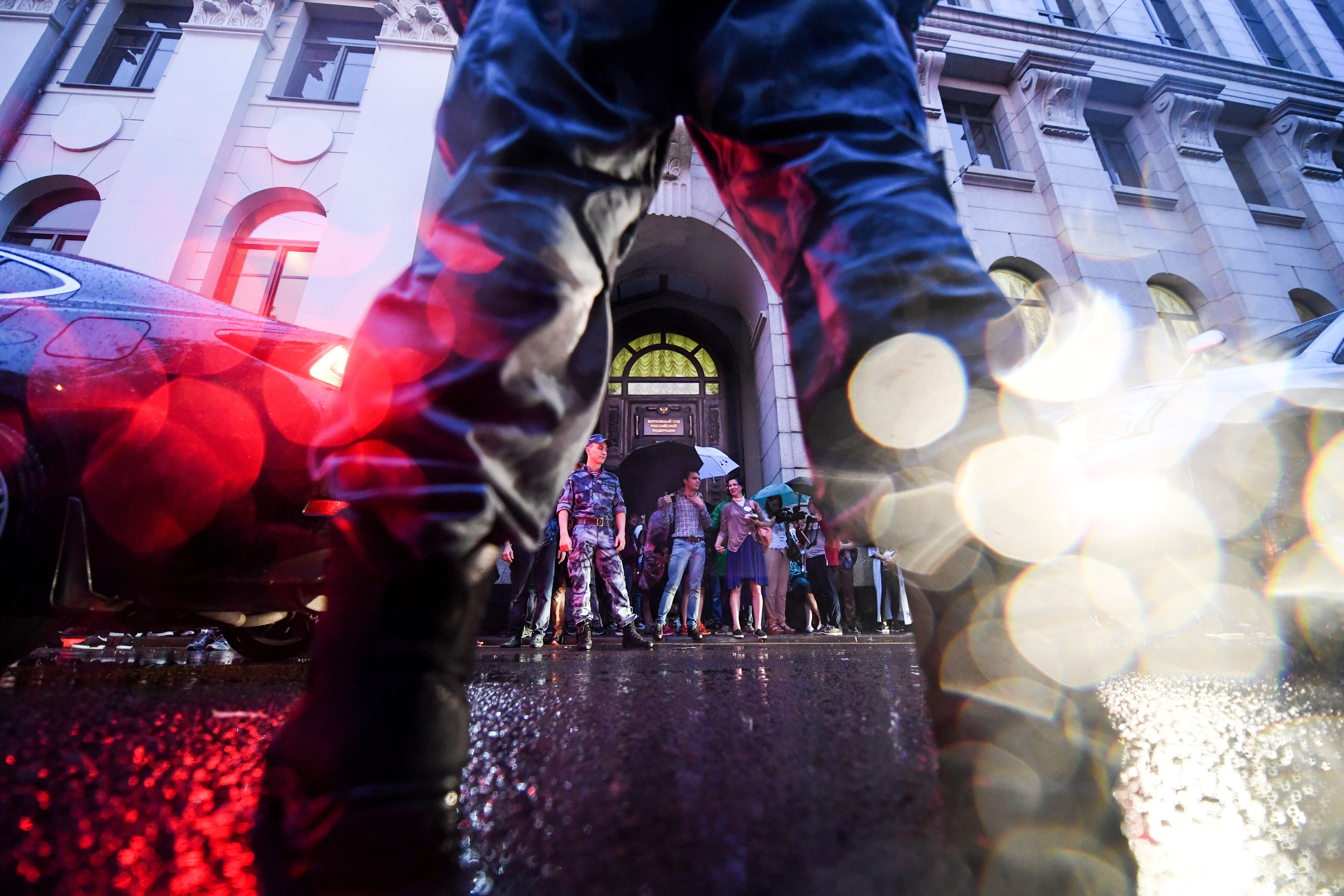 Russian riot policemen stand guard in front of the Russian Supreme court as people holding stuffed toys take part in a rally to demand the release of two teenagers accused of ‘extremism’