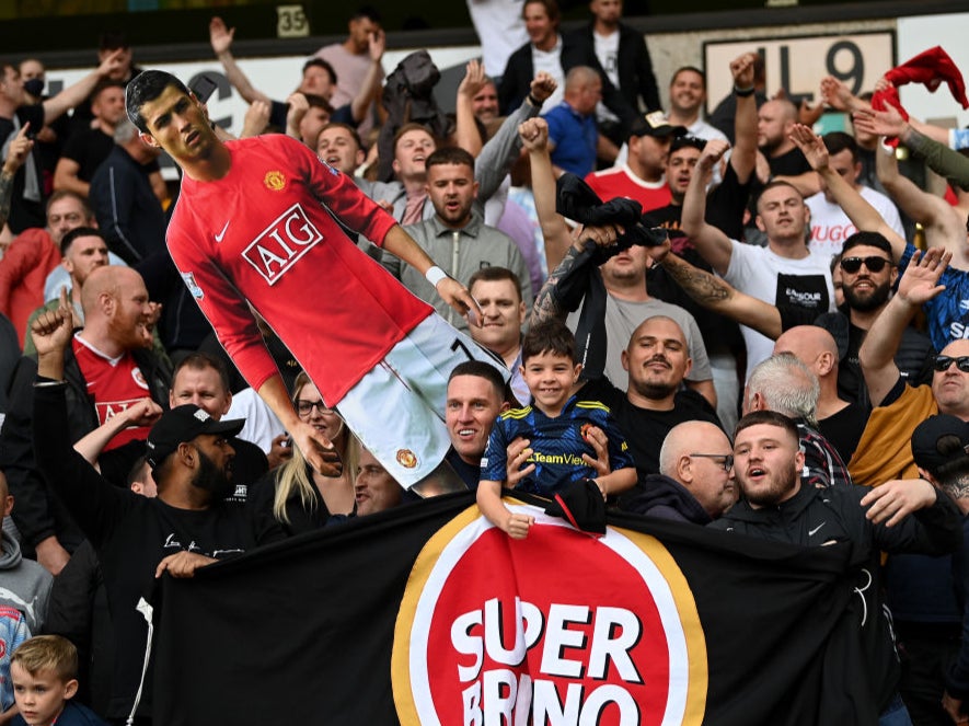 Manchester United fans hold up a cardboard cutout of Cristiano Ronaldo