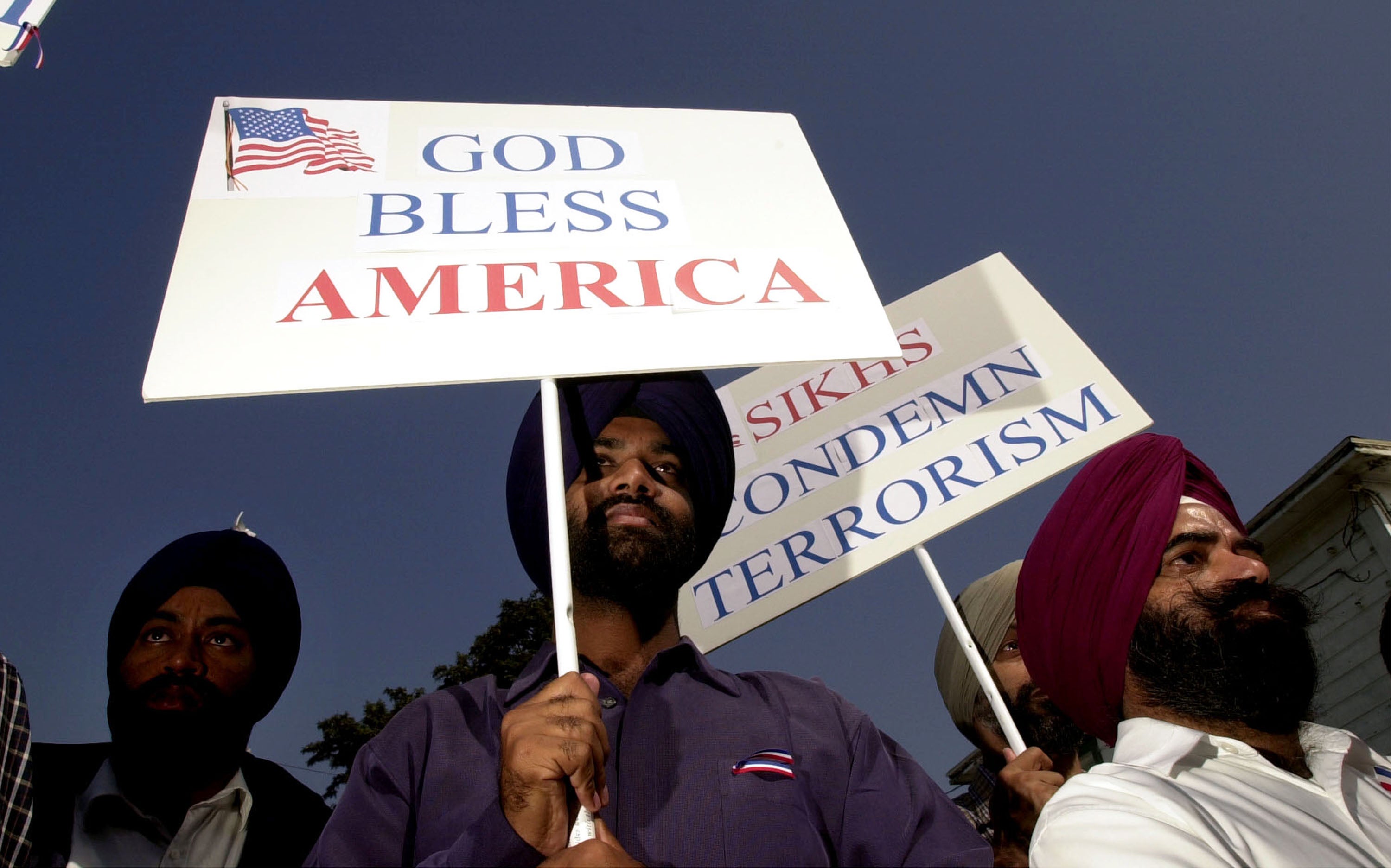 Sikh men carry patriotic placards at a community service to remember victims of terrorist attacks on 10 October, 2001 in Santa Ana