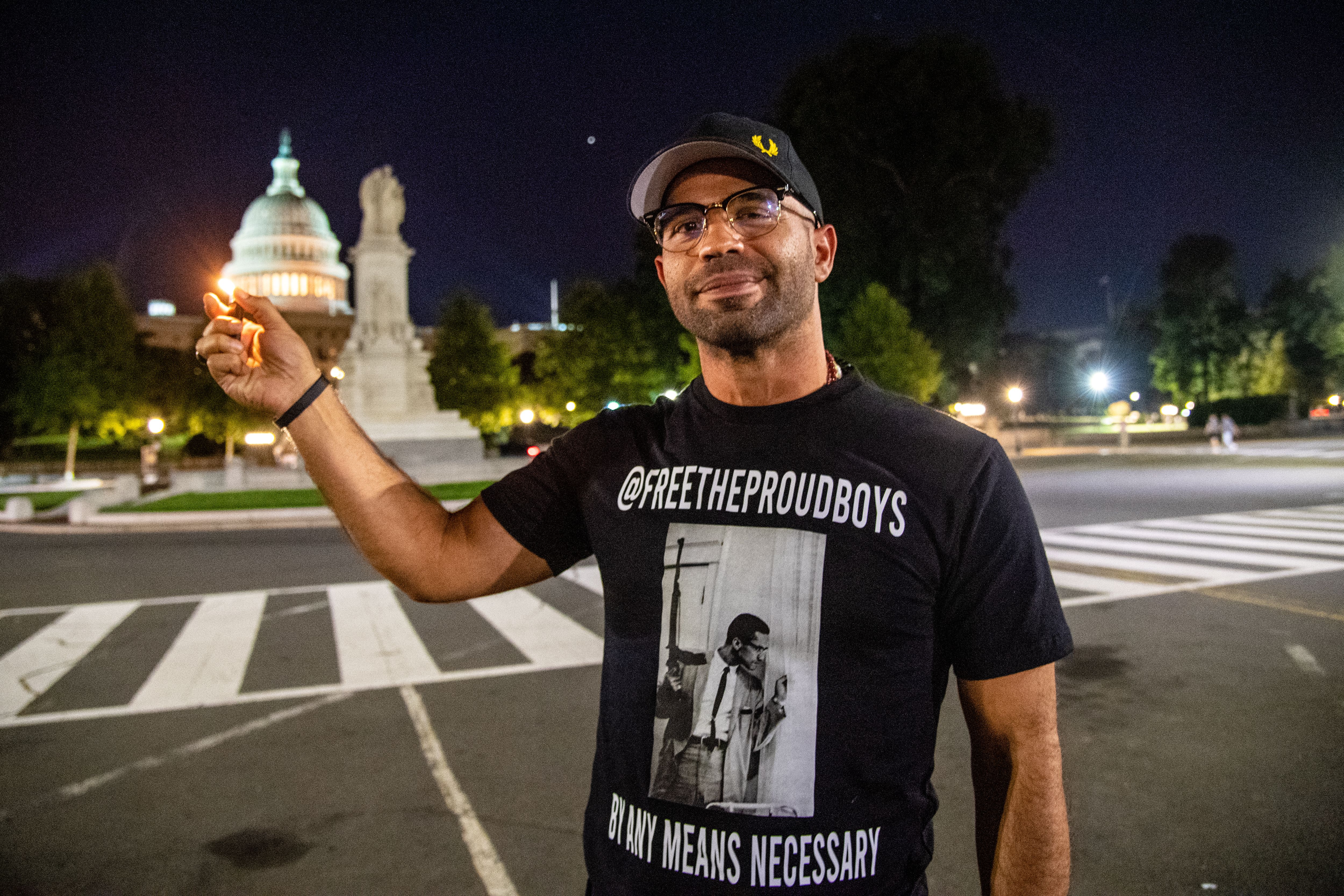 Enrique Tarrio holds up a lighter in front of the Capitol building before reporting for a five-month prison sentence.