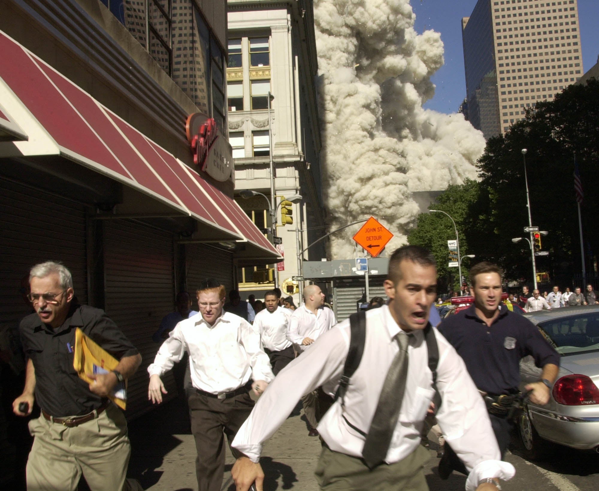 People run from the collapse of one of the Twin Towers