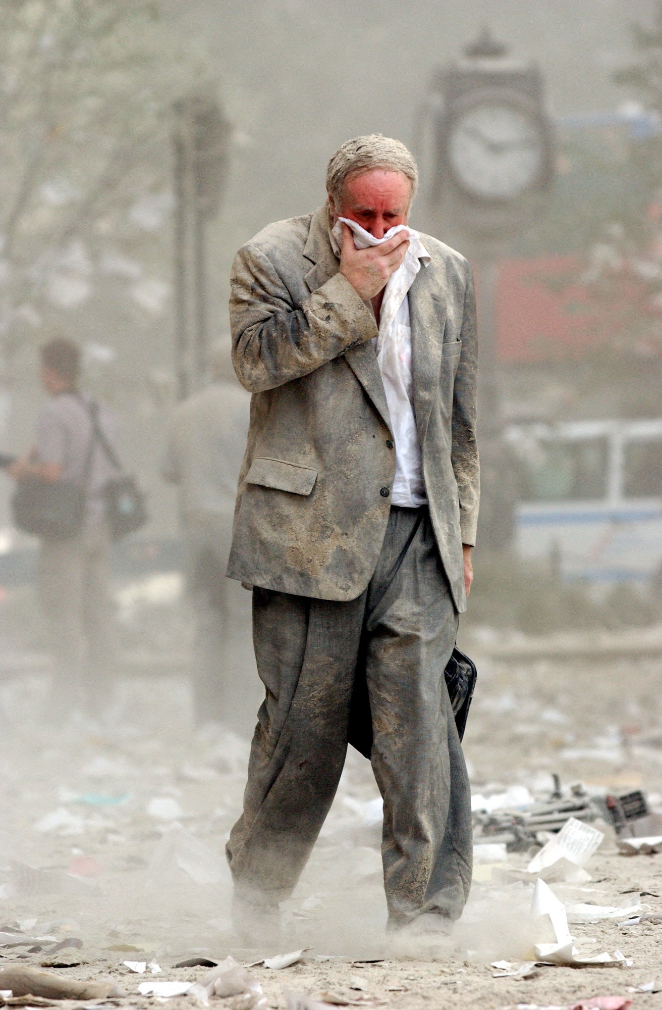 Survivor Edward Fine, who was on the 79th floor of the North Tower when it was struck, covers his mouth as he walks through the debris