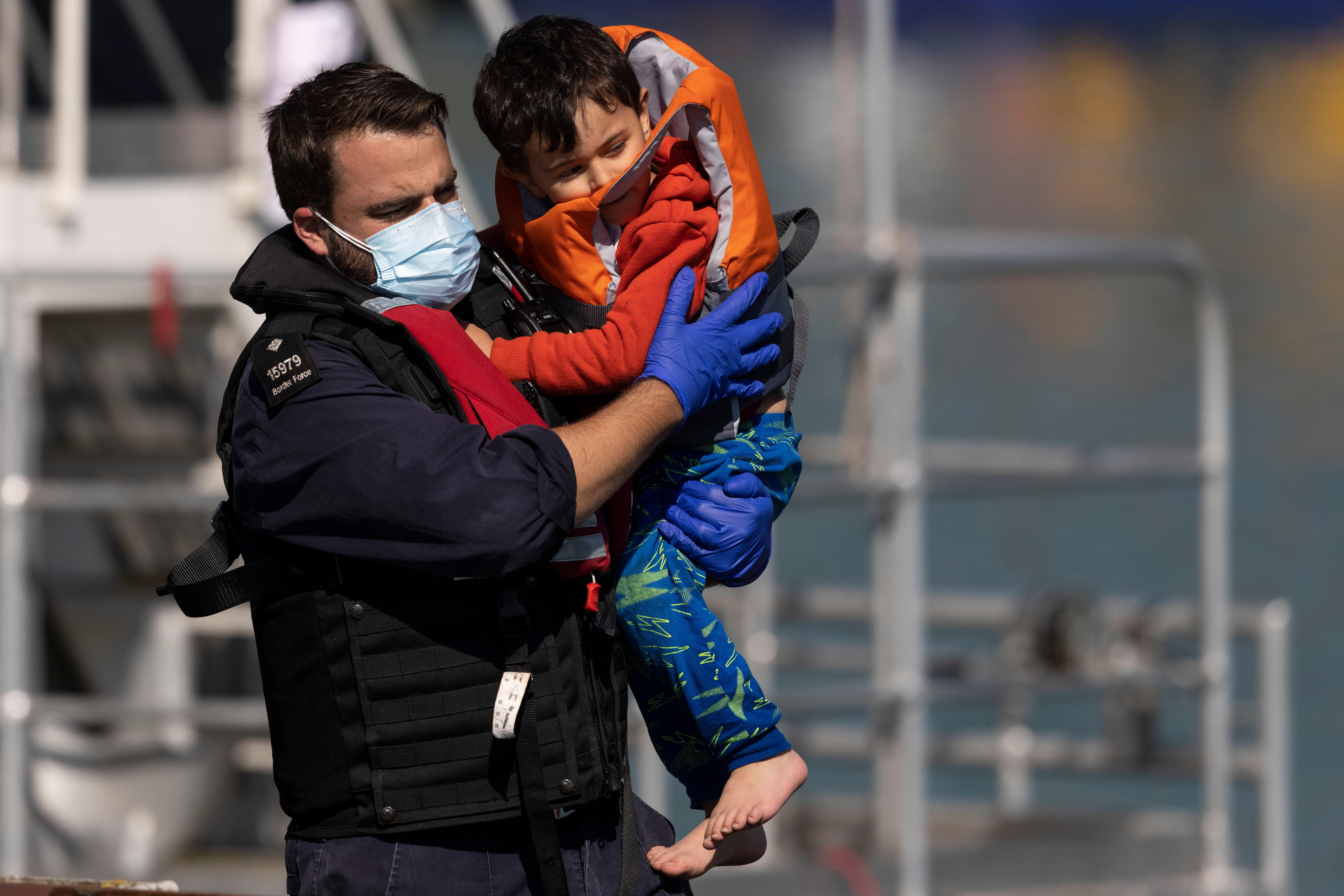 A young migrant boy is carried by a Border Force official after arriving into Dover docks on 8 September