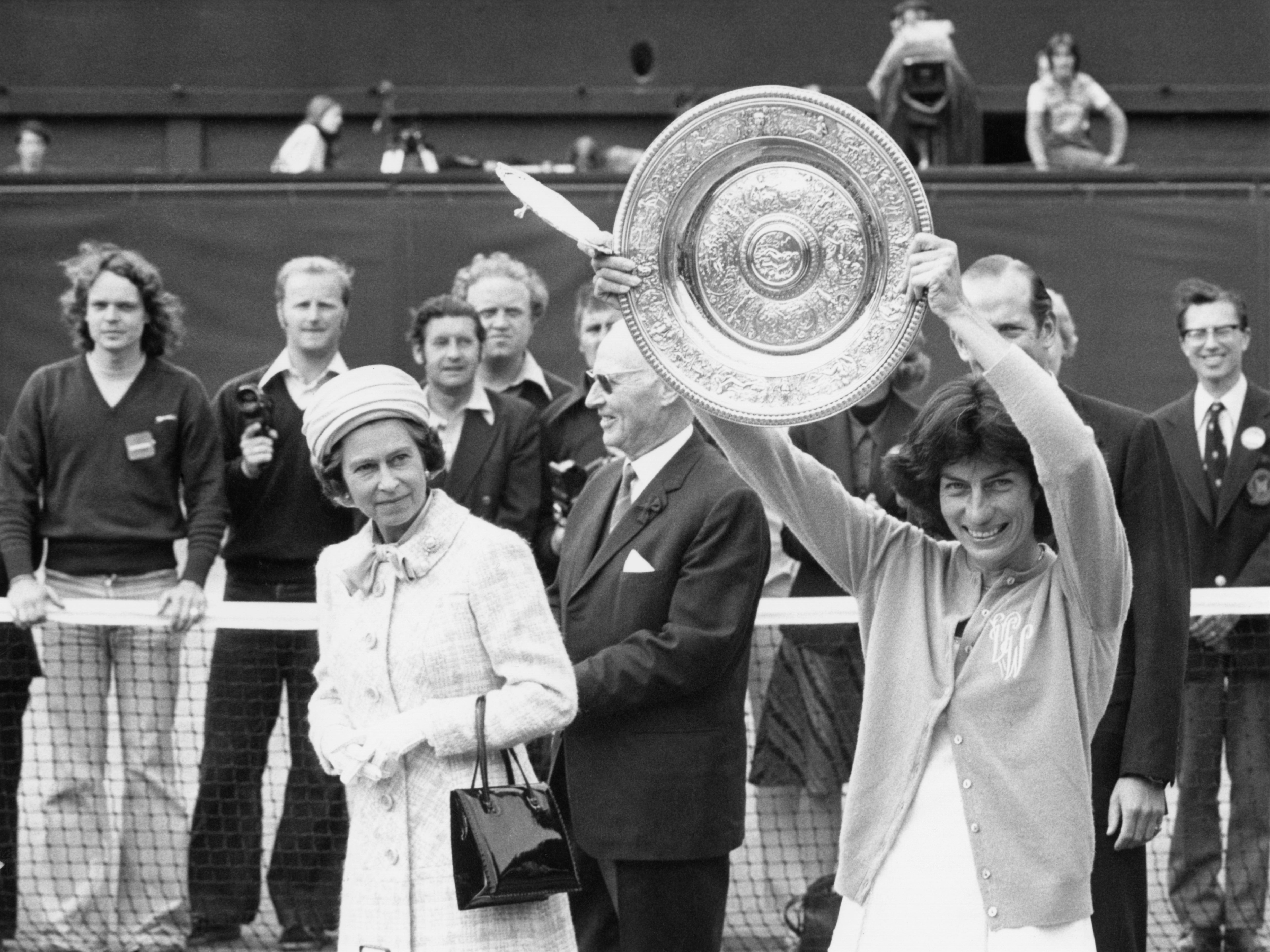 Queen Elizabeth II watches as Virginia Wade holds aloft the Wimbledon Women’s Singles trophy to the crowd on Centre Court on 1 July 1977