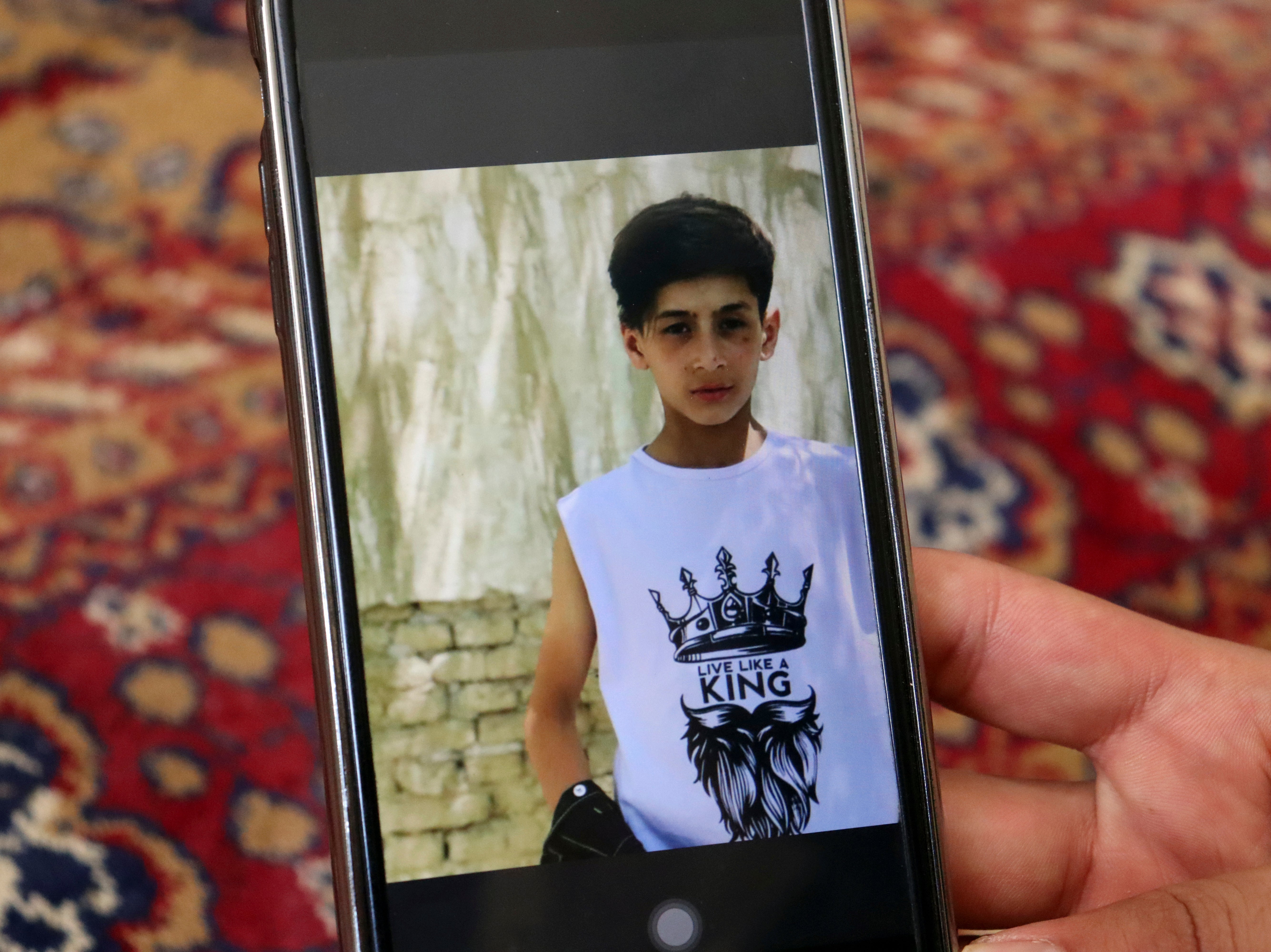 Emal Ahmadi shows a photo of his family member who was killed during a US drone strike on their home