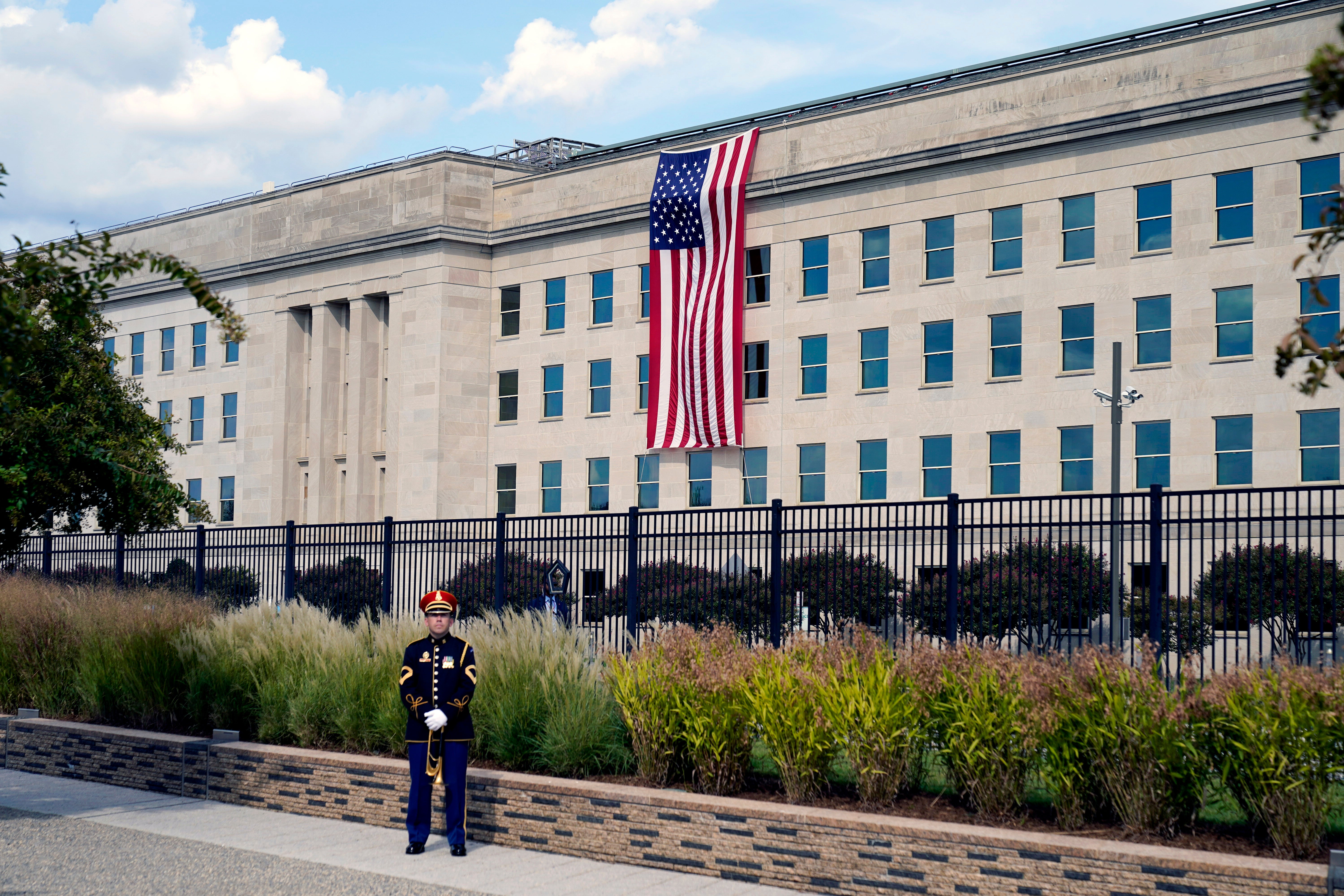 A U.S. Army band bugler stands ready on the National 9/11 Pentagon Memorial site for a ceremony with President Joe Biden, first lady Jill Biden, Vice President Kamala Harris and her husband Douglas Emhoff, Secretary of Defense Lloyd Austin and Joint Chiefs Chairman Gen. Mark Milley, Saturday, Sept. 11, 2021 at the Pentagon in Washington, on the 20th anniversary of the terrorist attacks. The National 9/11 Pentagon Memorial, opened in 2008, commemorates the lives lost at the Pentagon and onboard American Airlines Flight 77. (AP Photo/Alex Brandon)