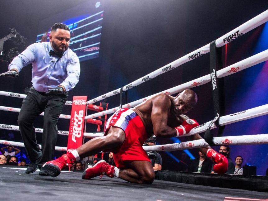 Evander Holyfield falls through the ropes