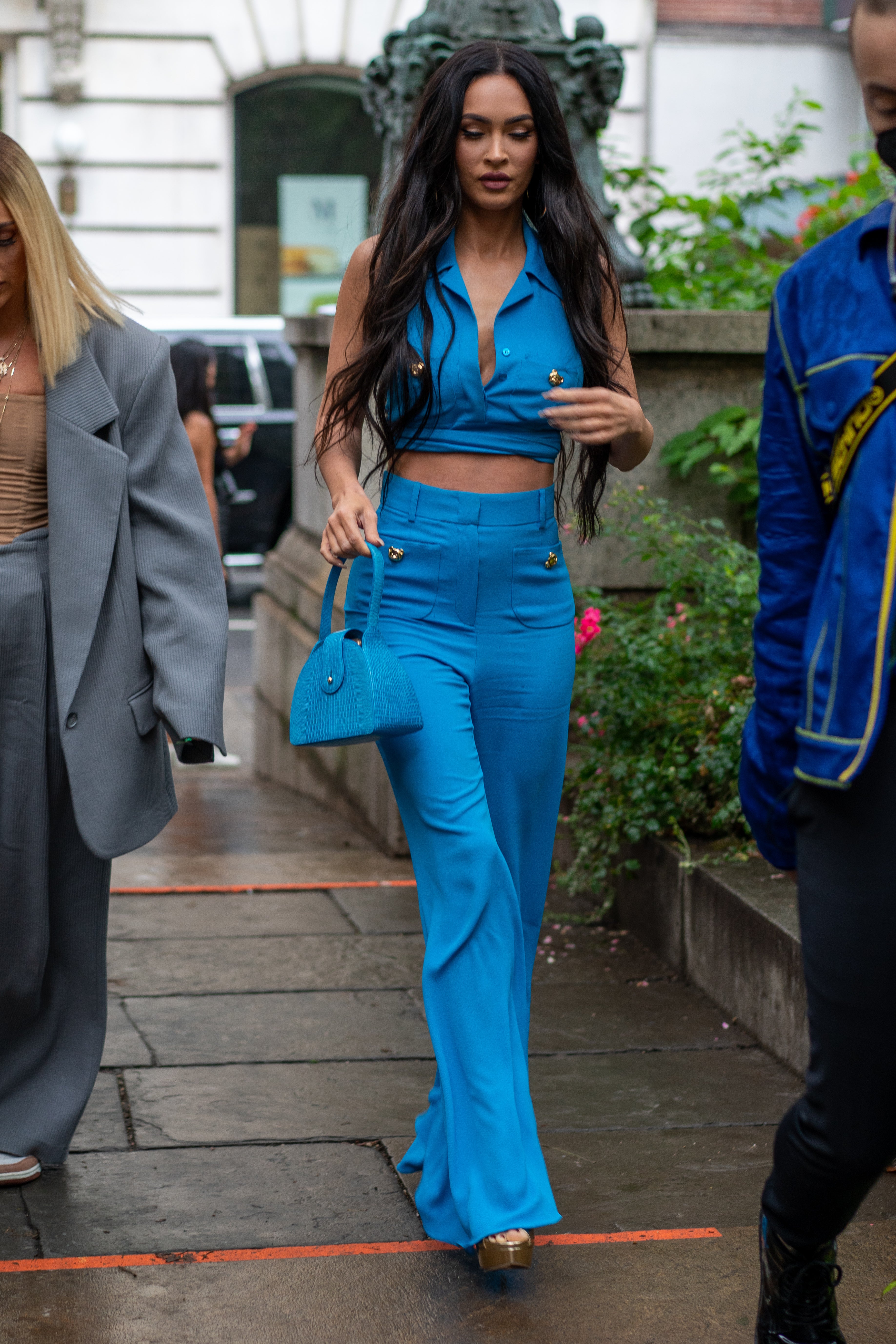 The actor arrived at the Moschino show in a vibrant blue two-piece complete with wide-leg trousers, gold buttons, and a matching handbag.