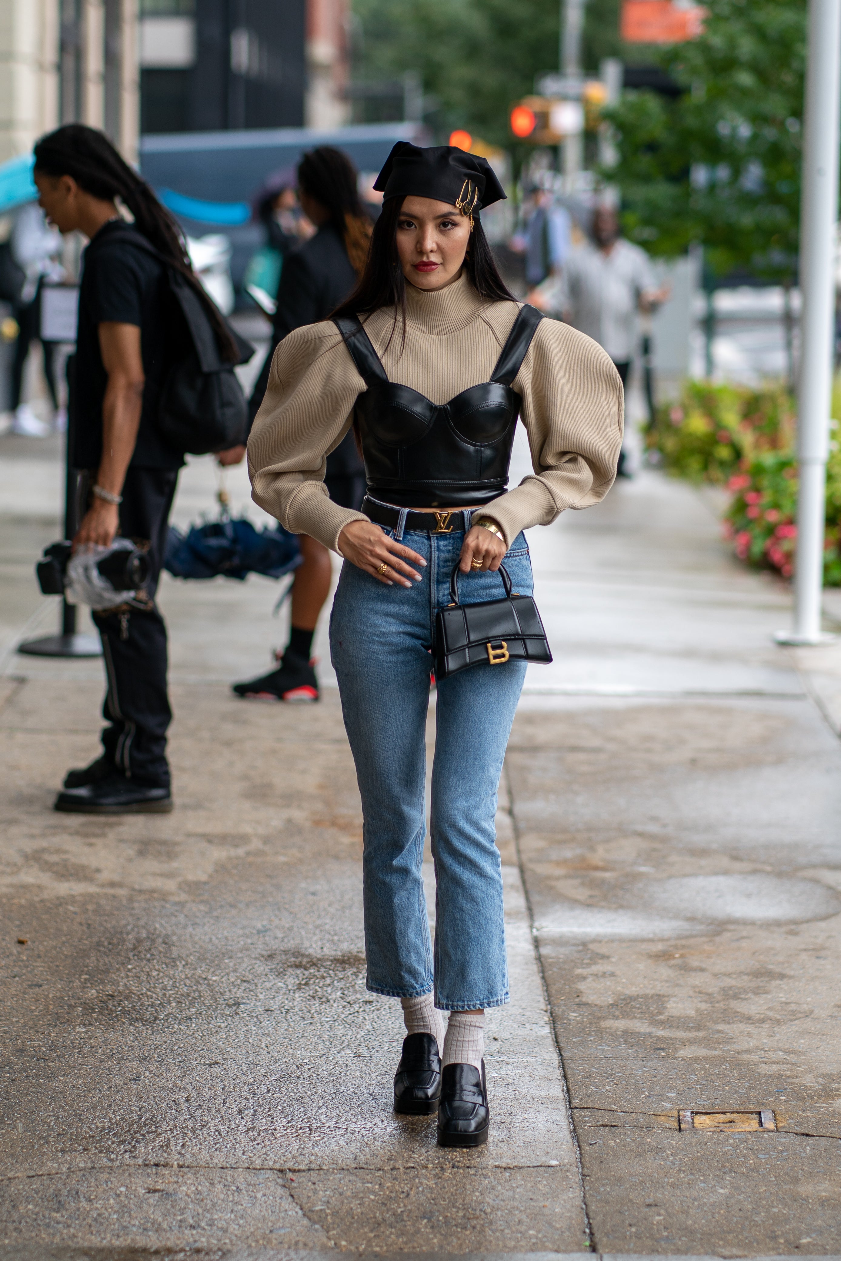 The fashion influencer arrived at the Duo Doux show in a black leather top and jeans by GRLFRND. She also wore a belt by Louis Vuitton, and a Balenciaga handbag.