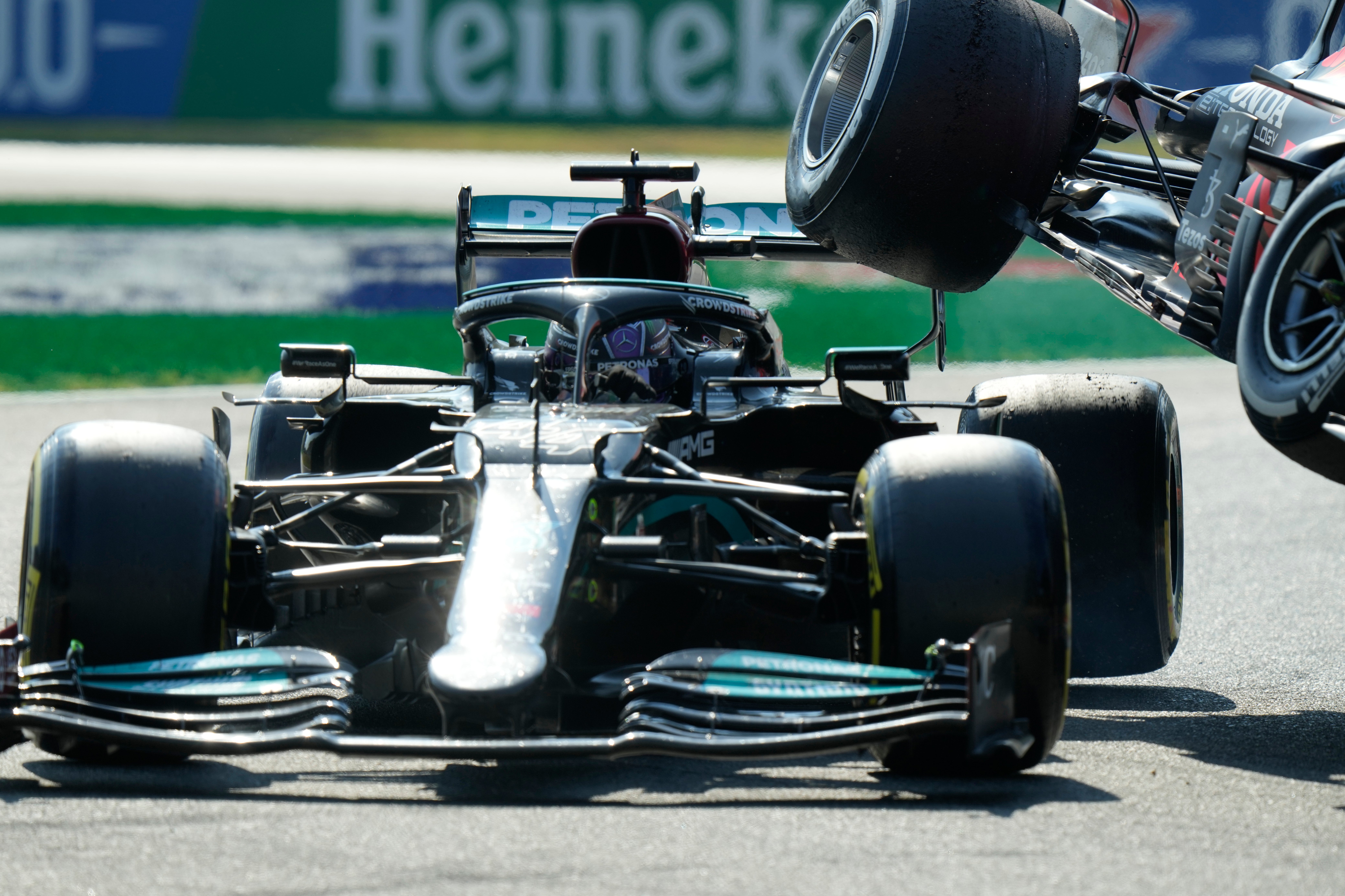 Mercedes driver Lewis Hamilton of Britain crashes with Red Bull driver Max Verstappen of the Netherlands during the Italian Formula One Grand Prix, at Monza racetrack, in Monza, Italy, Sunday, Sept.12, 2021. (AP Photo/Luca Bruno)