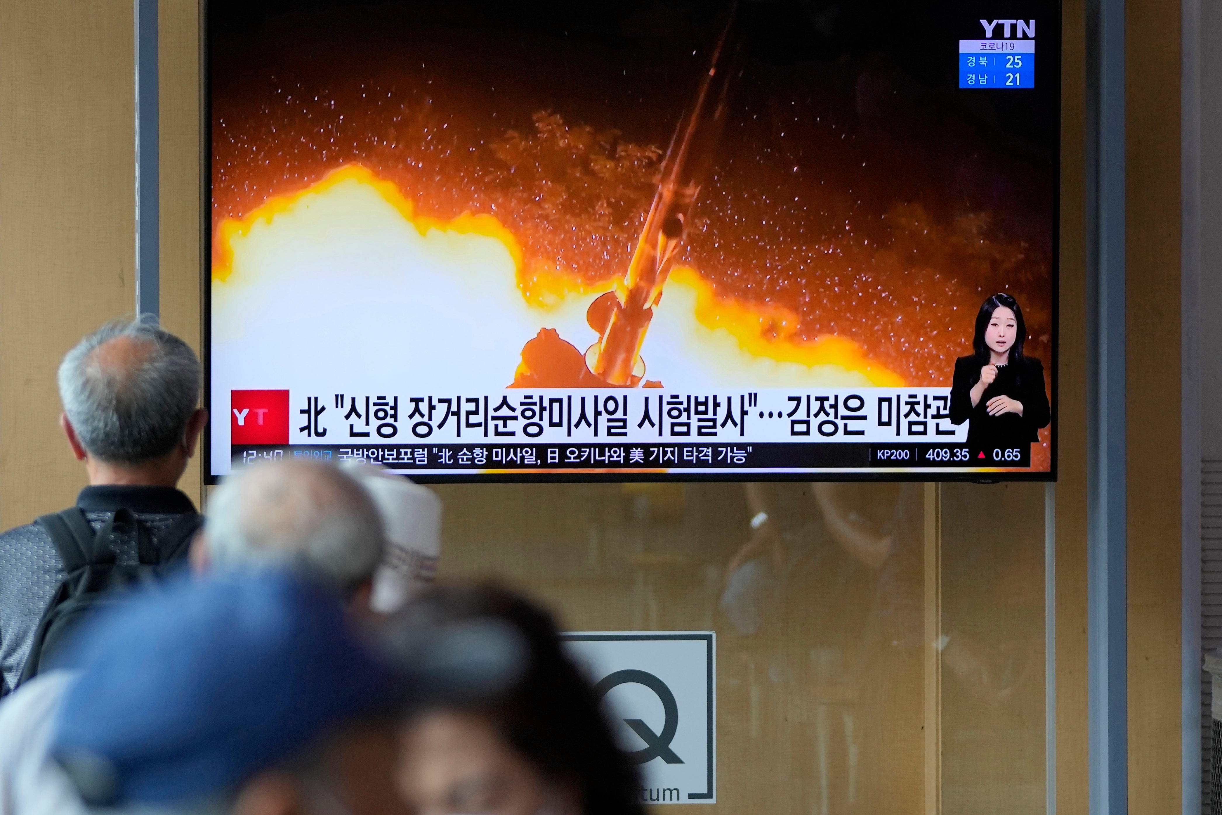 Seoul residents watch a news show featuring a North Korean handout photo captioned, ‘North Korea’s long-range cruise missiles tests’