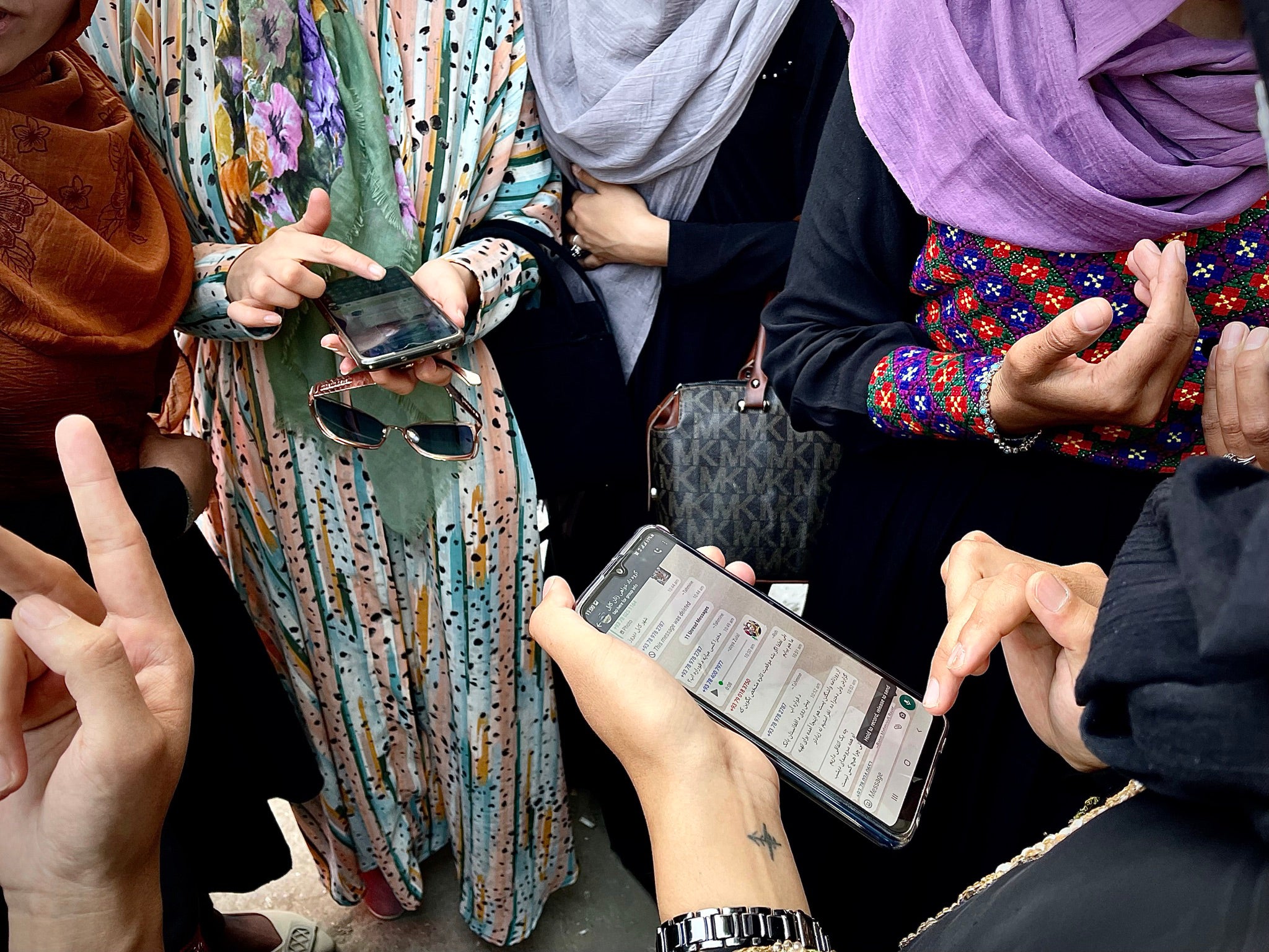 Female protesters compare messages from other groups marching in Kabul