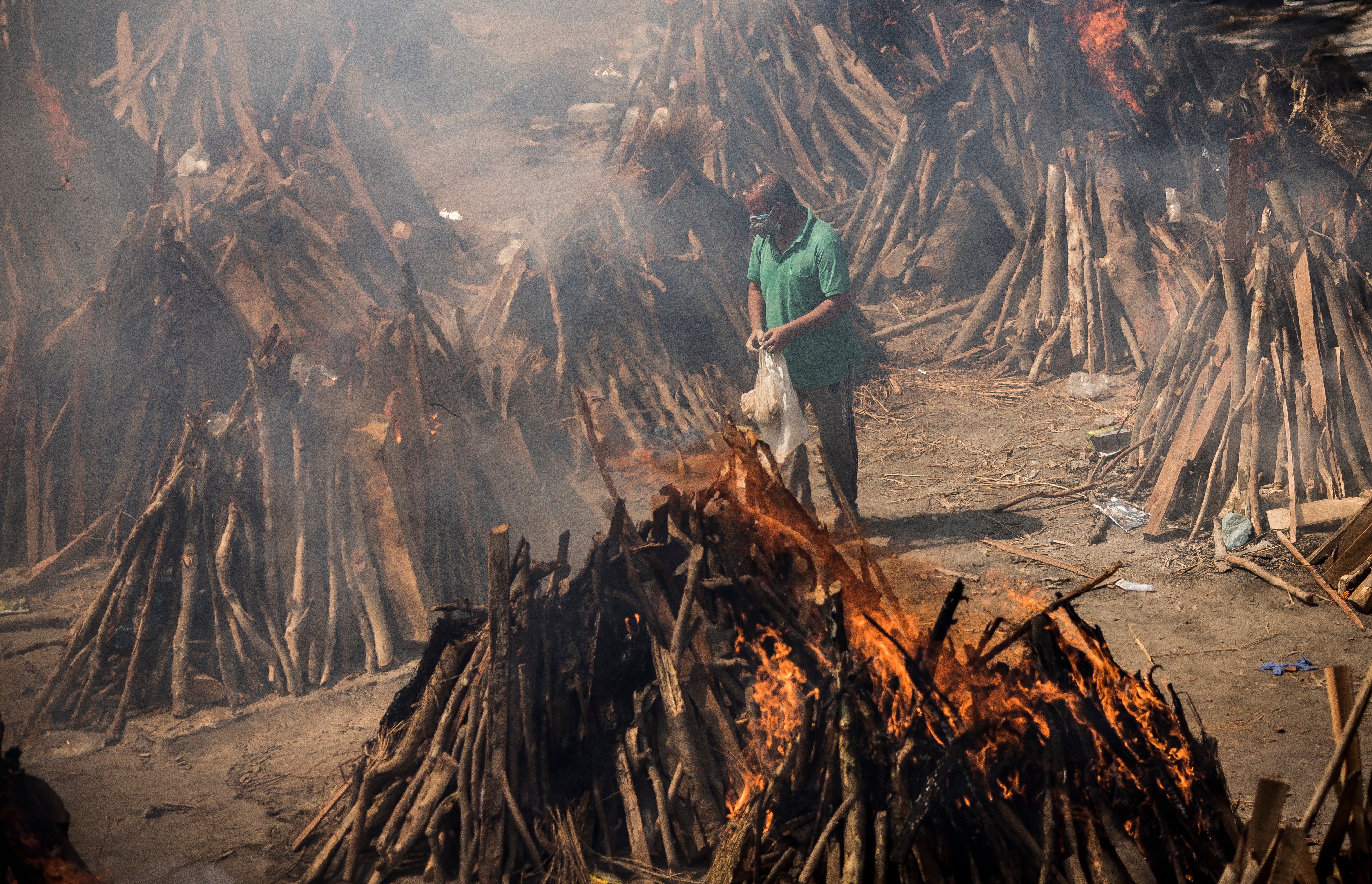 A man performs the last rites of his relative who died from Covid-19 during a mass cremation in Delhi, in April 2021