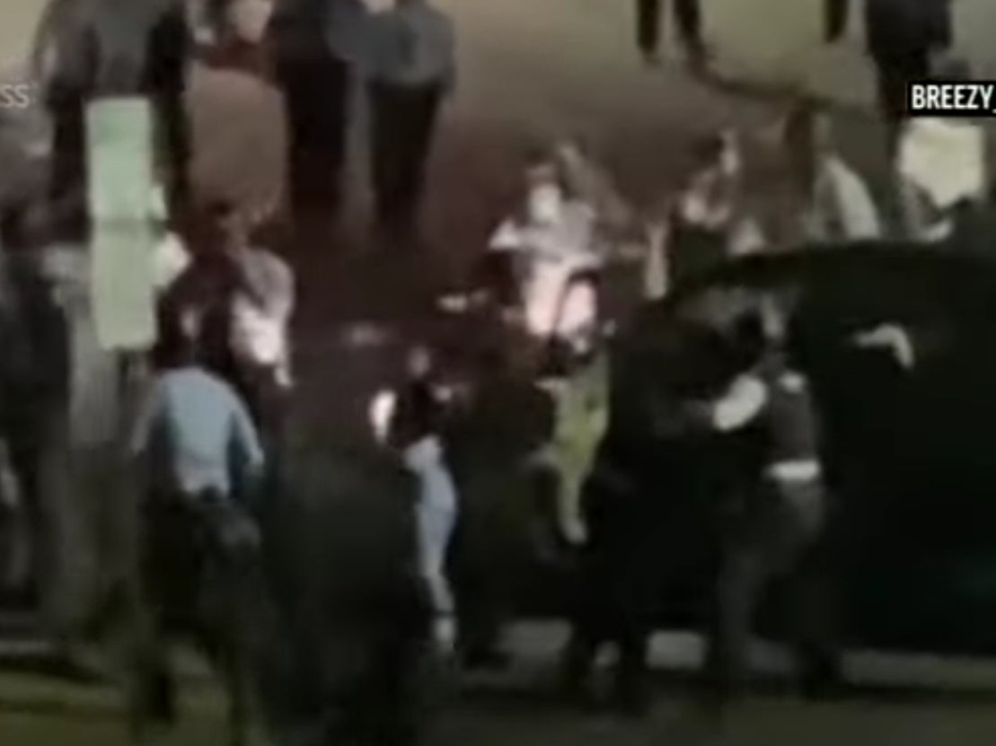 A screengrab of video showing officers and protesters surround Rickia Young’s vehicle