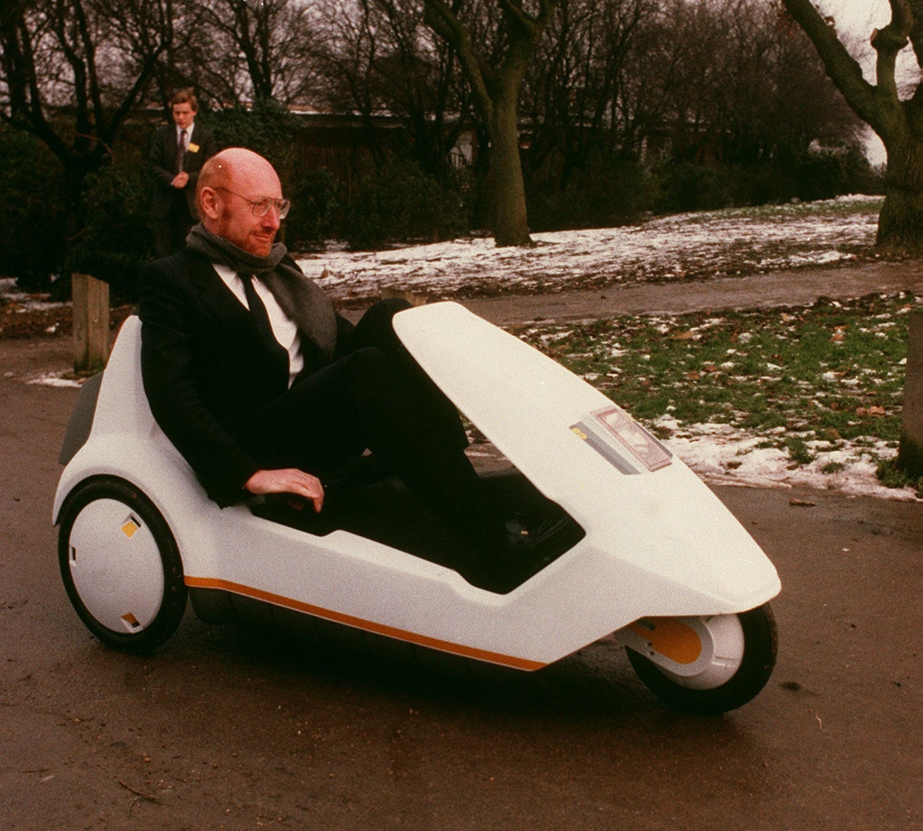 Sir Clive Sinclair demonstrates his battery-assisted pedal powered tricycle on January 10, 1985 in Alexandra Palace, London