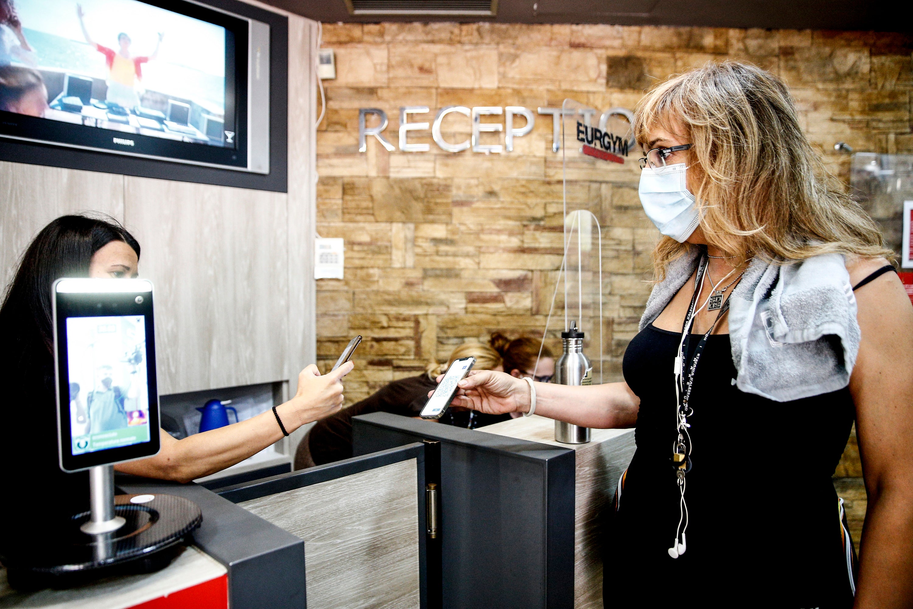 File: A customer has her green pass checked at the entrance of a gym in Rome