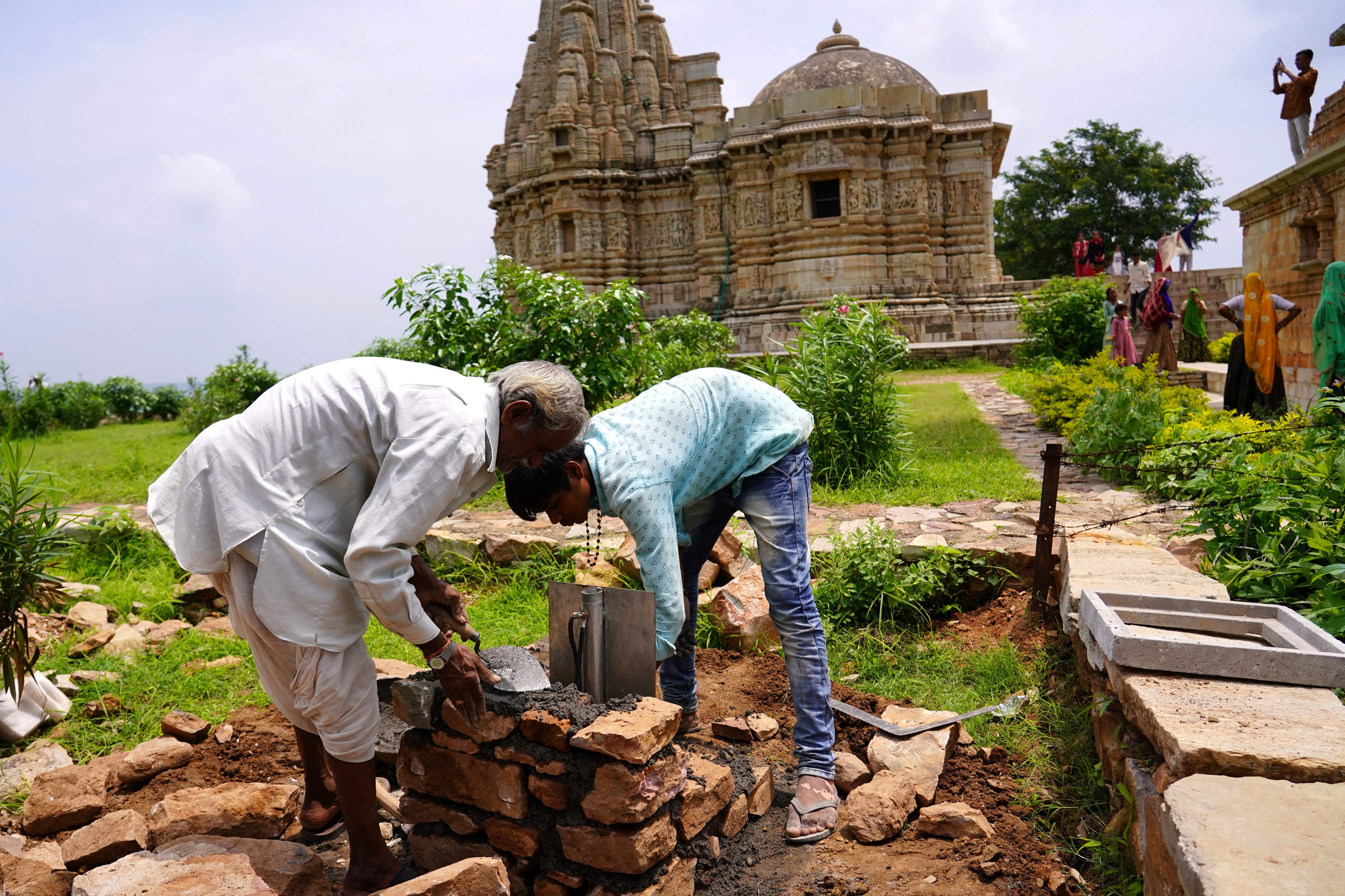 Workers installing a new lighting rod on a fort in Chittorgarh, India, after the structure was damaged by a strike