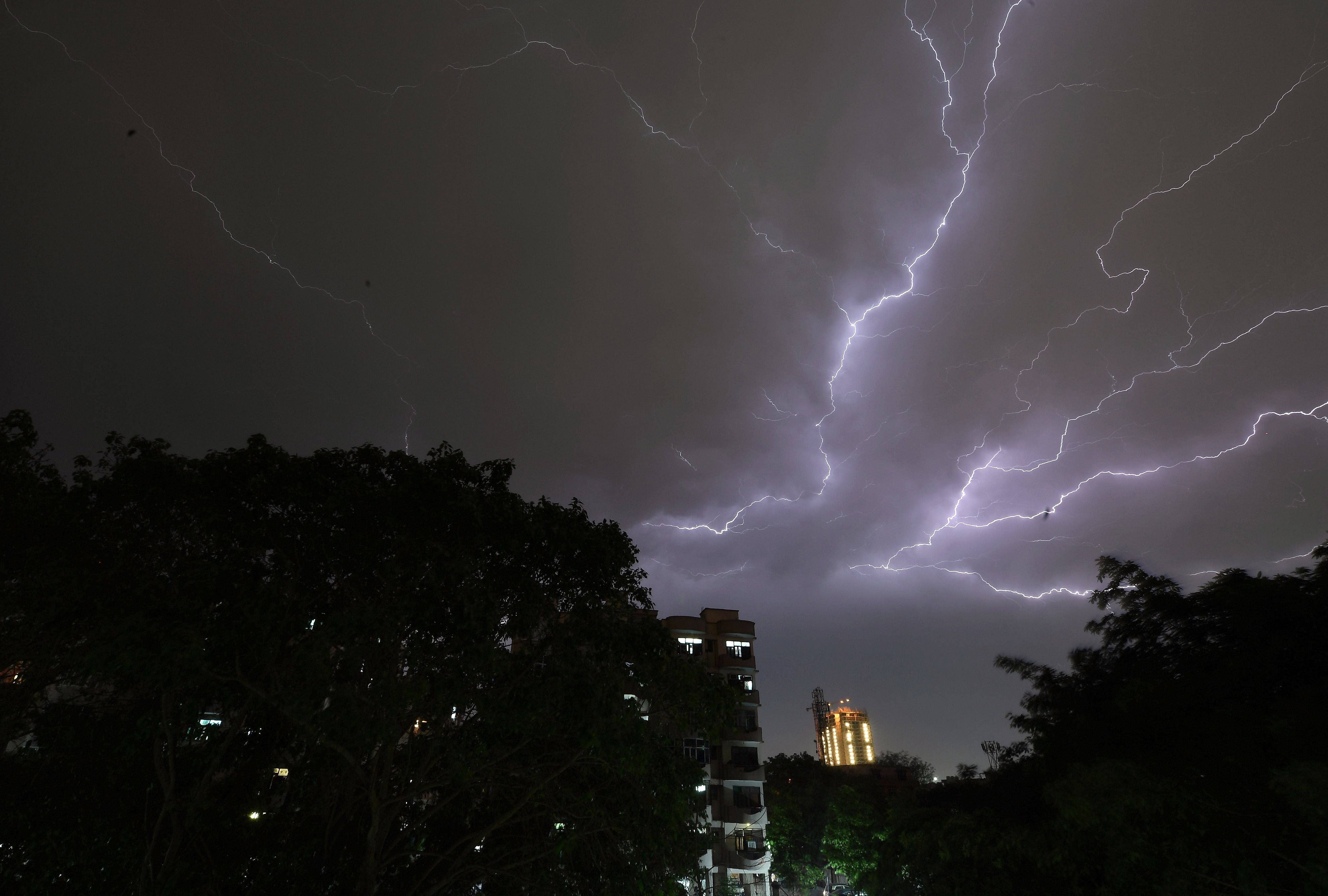 Lightning strikes over residential apartments during a thunderstorm on the outskirts of the Indian capital Delhi