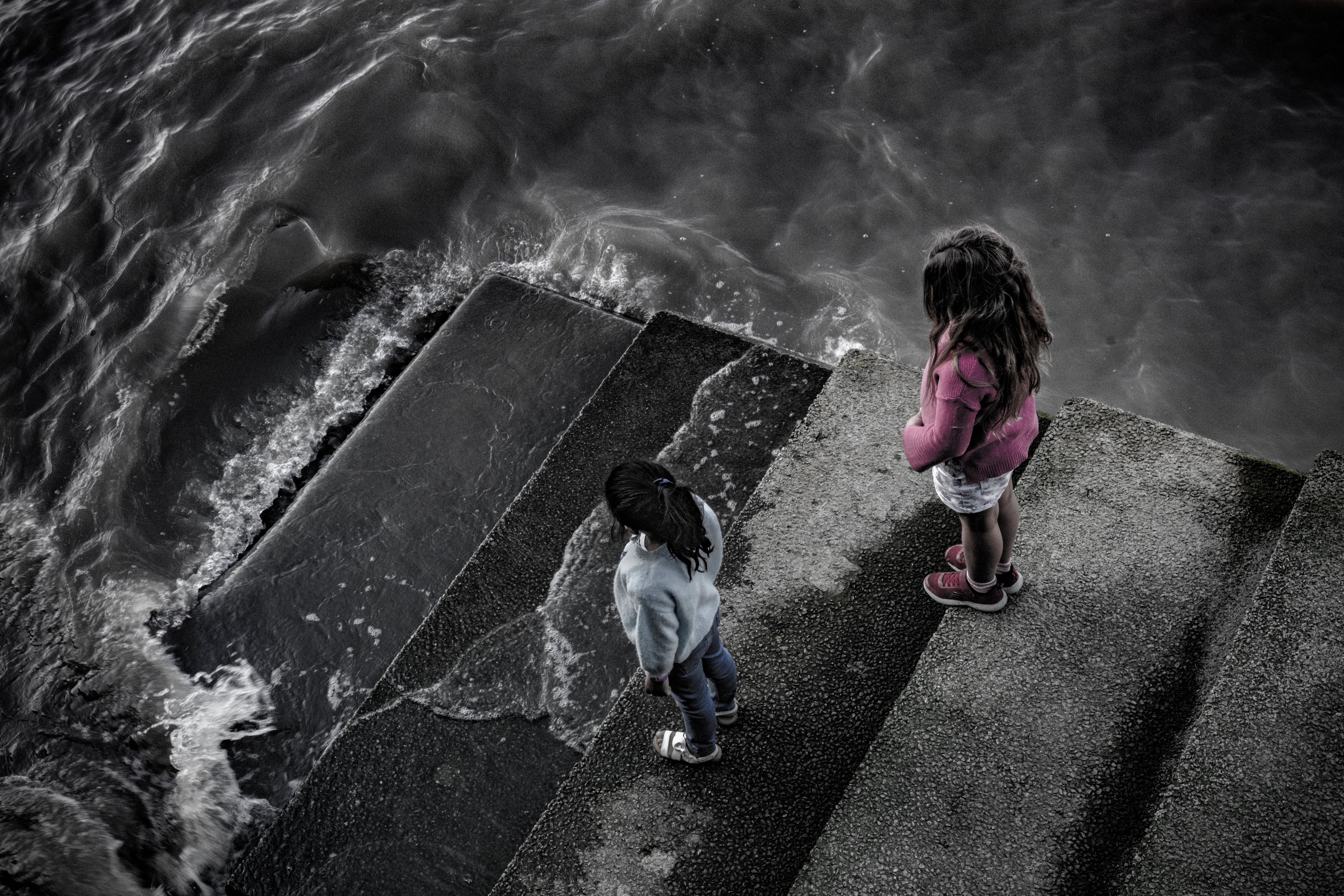 Elizabeth, six, left, and Mali, eight, watch the tide coming in on the Thames; as global sea levels rise, cities on coasts and tidal rivers will be first to feel the effects of increased flooding and will take the worst of the impacts