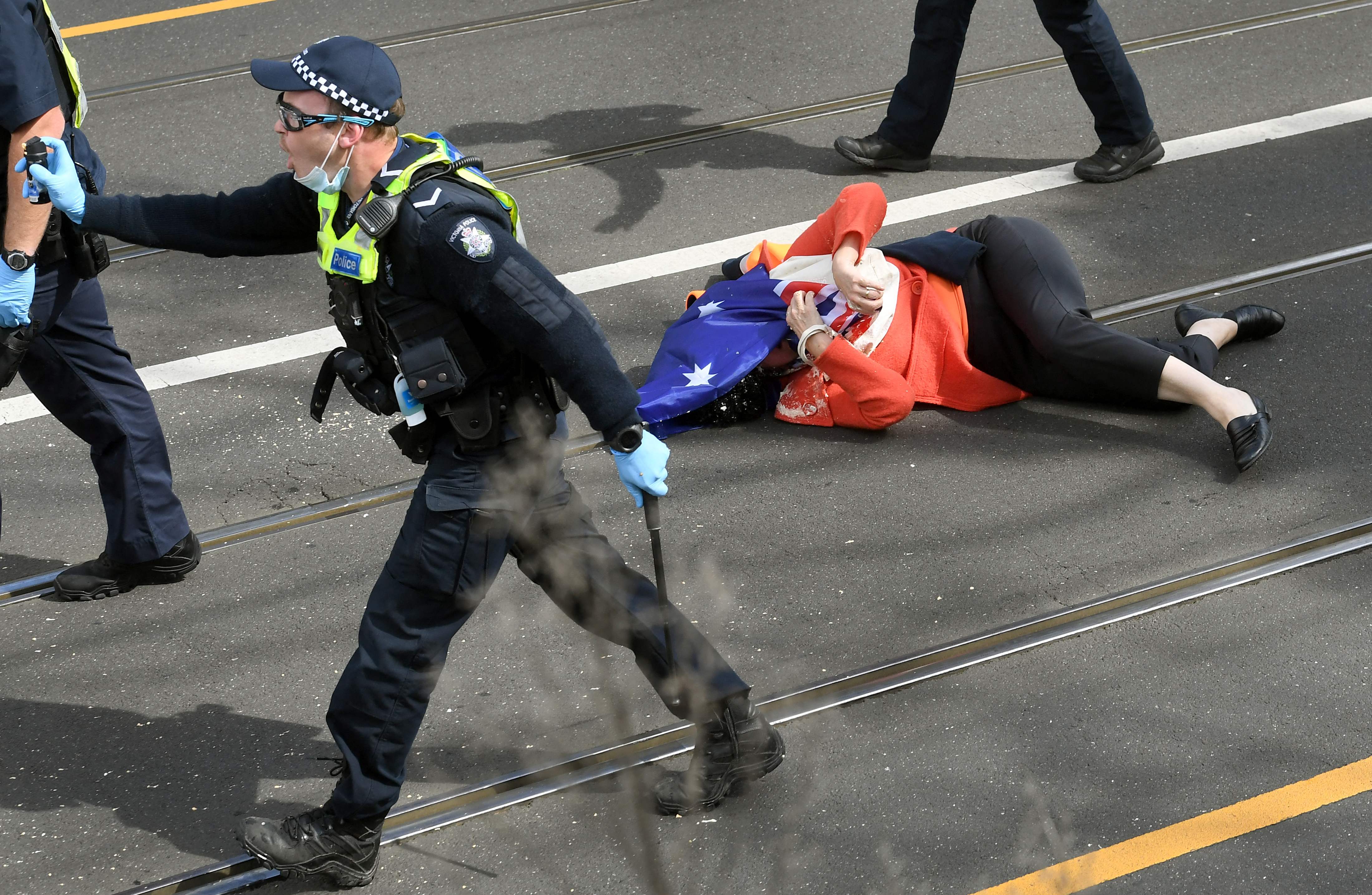 A protester who was pushed to the ground by the police after being pepper sprayed