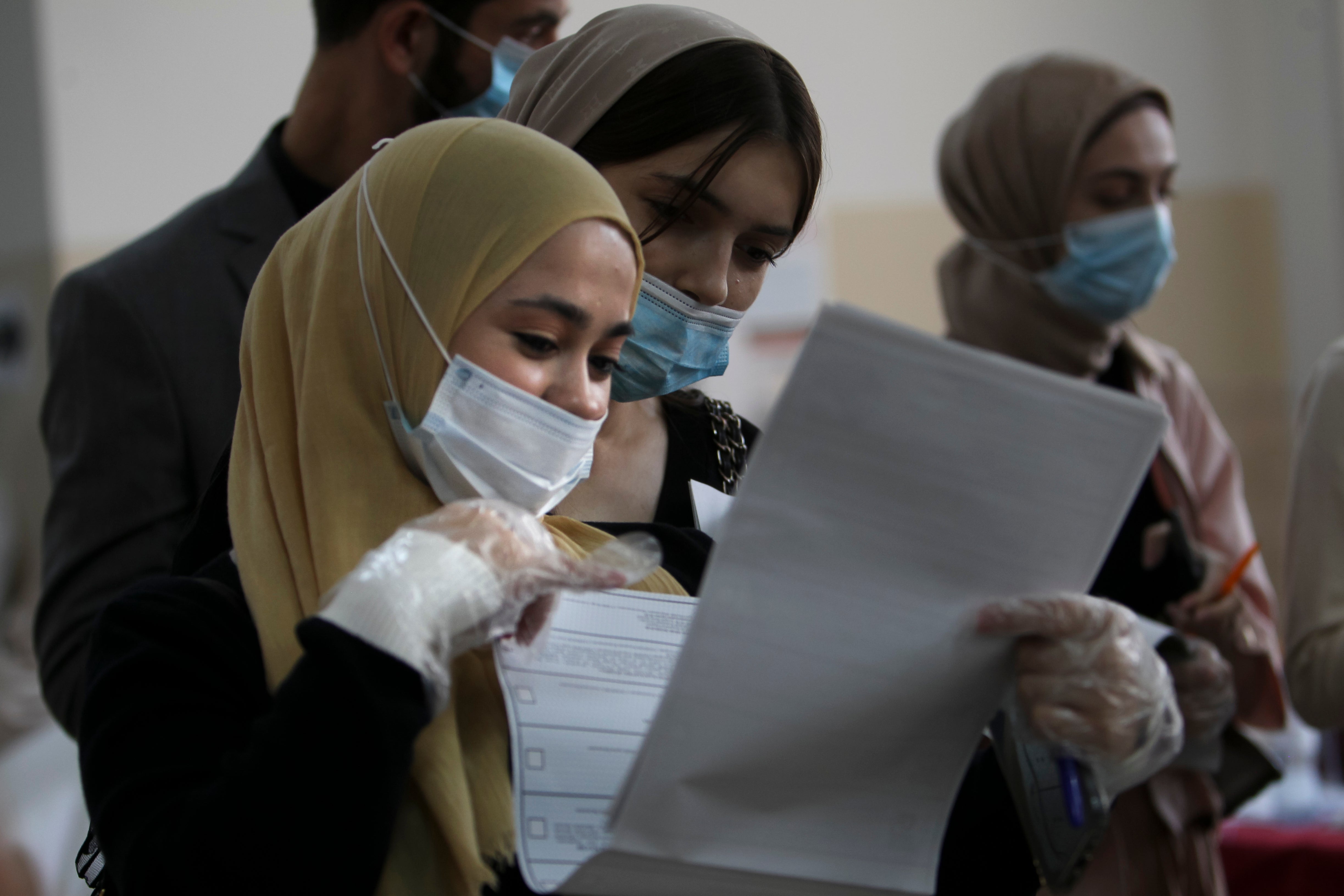 Chechen women wait to fill in their ballots at a polling station during the elections in Grozny, Russia