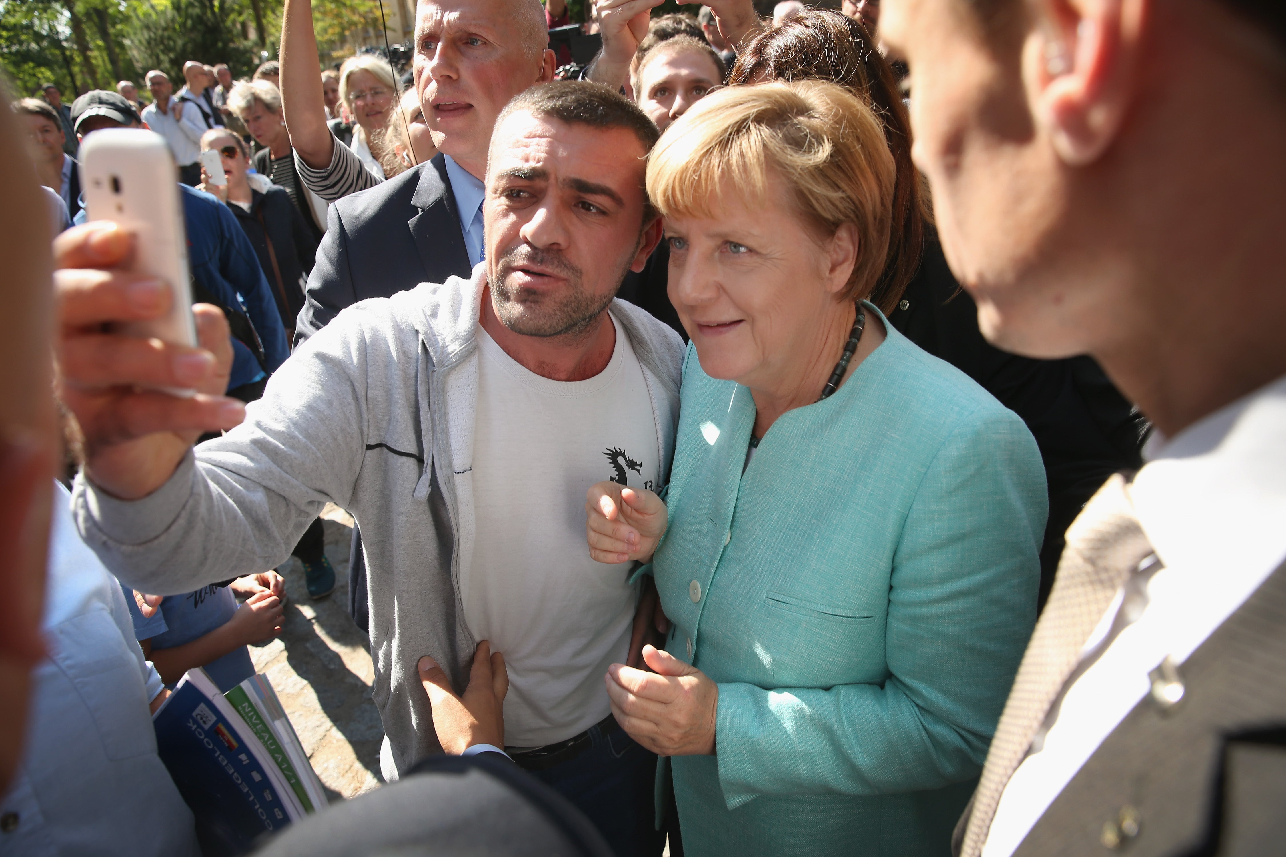 Merkel pauses for a selfie with a migrant after she visited a centre for asylum-seekers. Progress in integration is something the new chancellor will need to watch