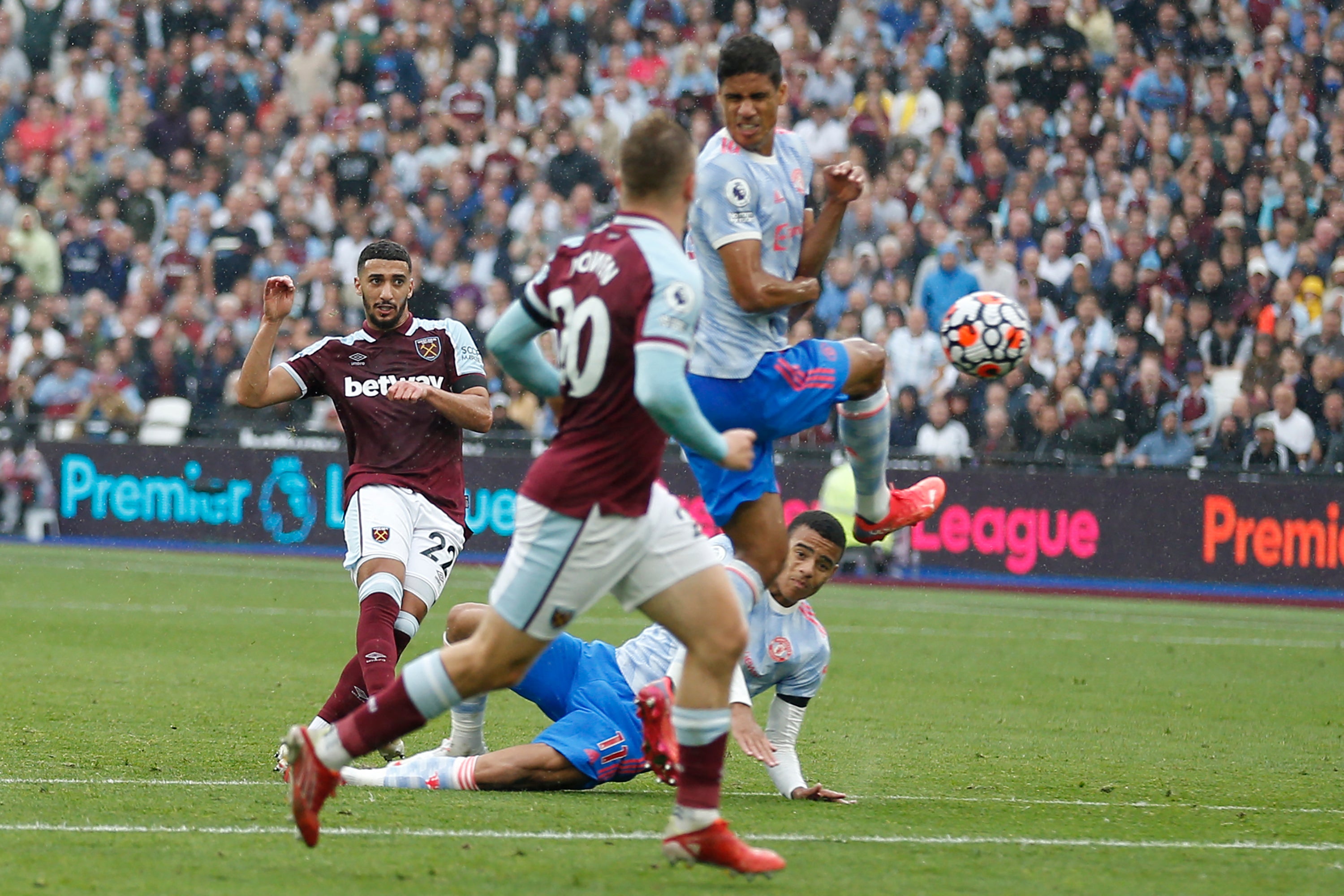 Algerian midfielder Said Benrahma (left) sees his shot deflected into the goal by Raphael Varane (right)