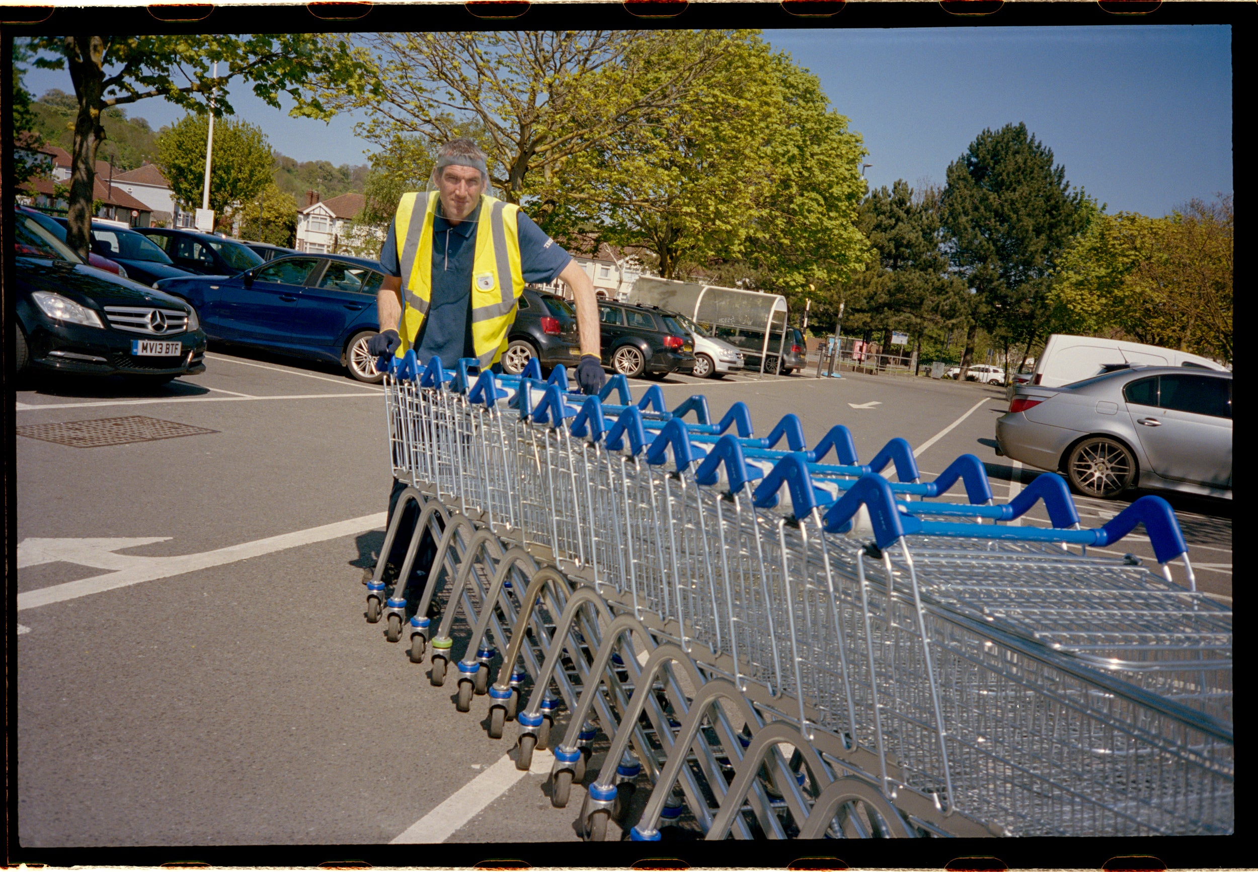 A Tesco trolley collector wearing a visor