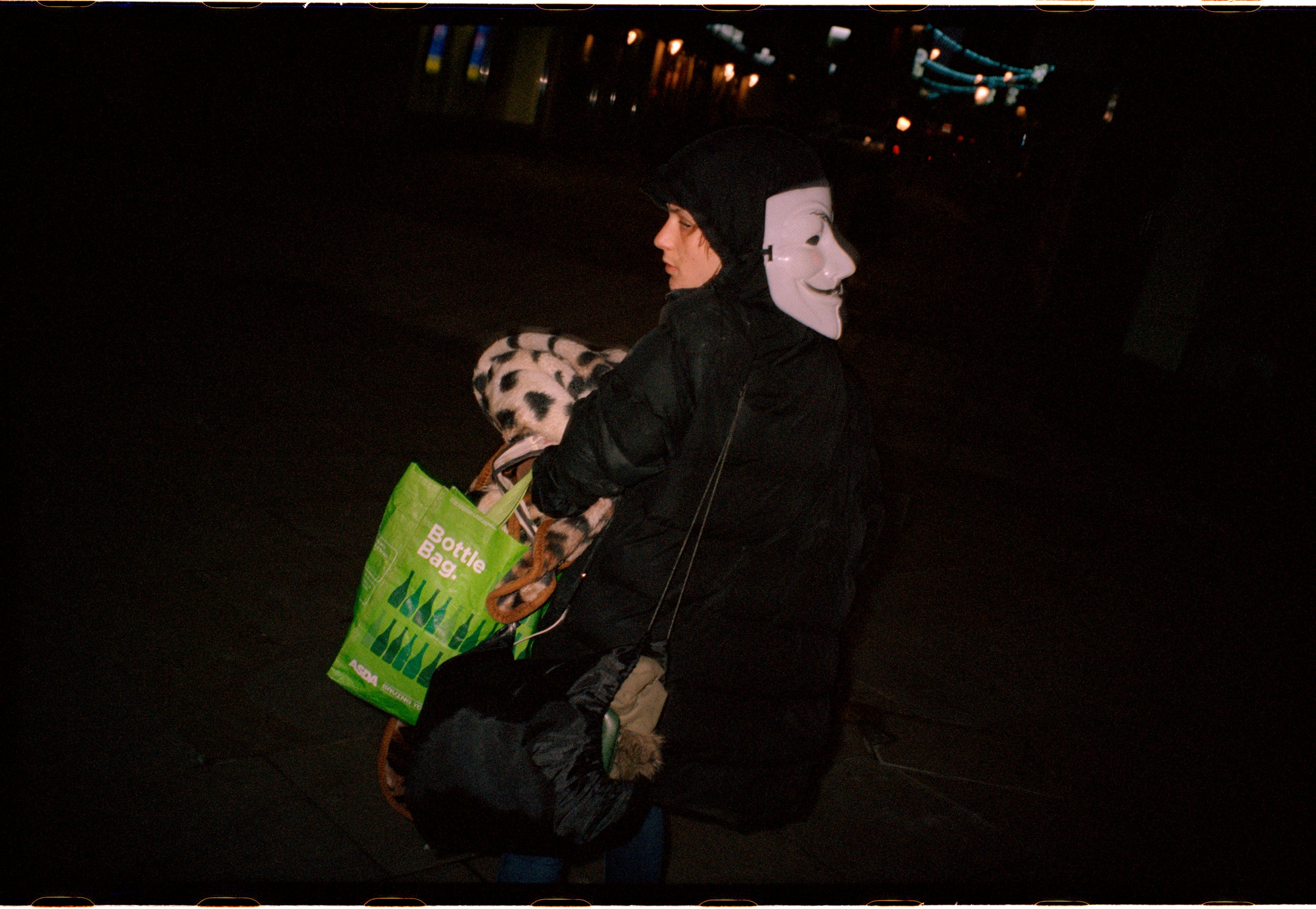 A girl walks through the centre of the city with her sleeping bag in her arm