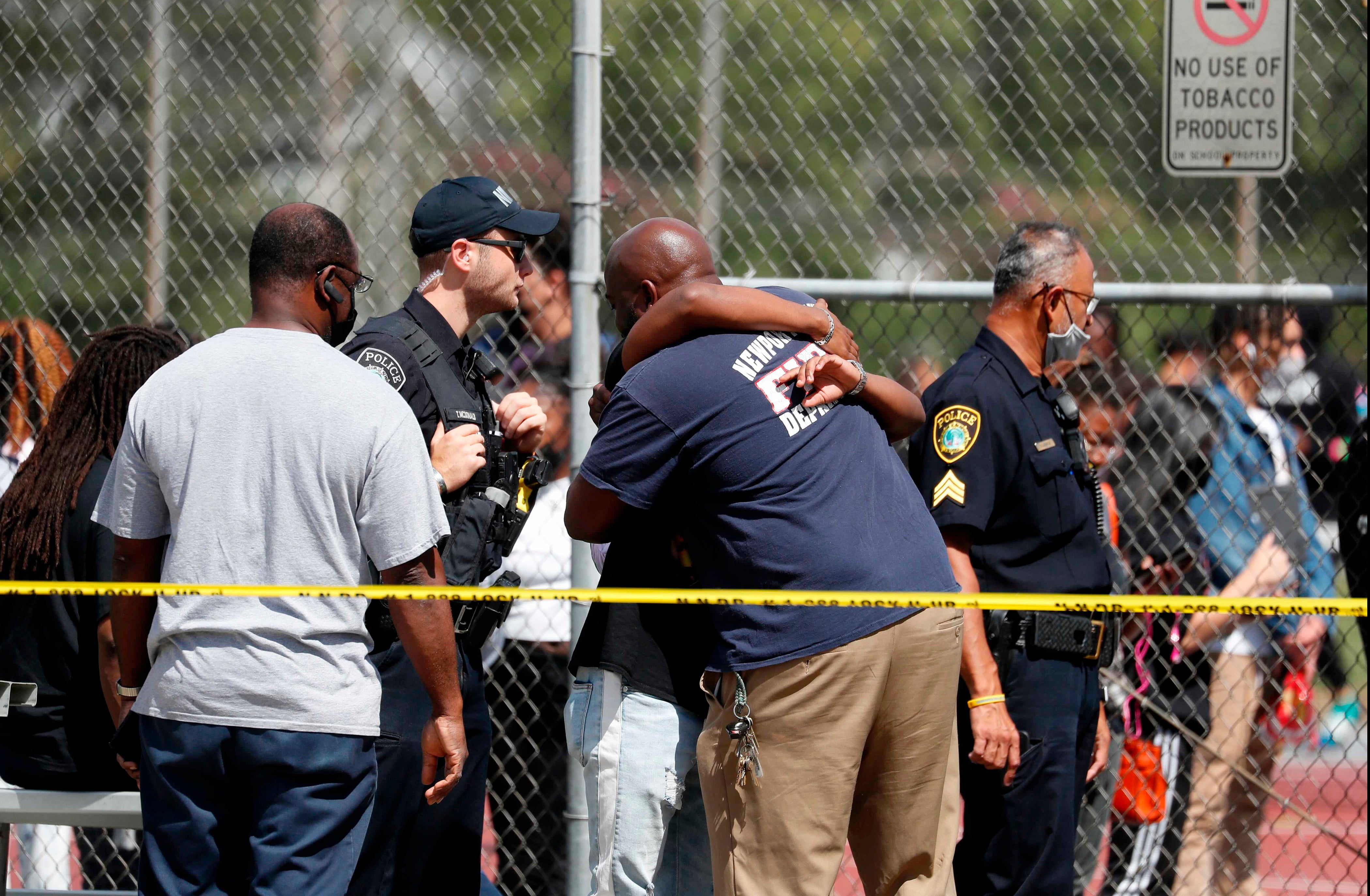 People embrace outside Heritage High School as Newport News Police are on scene responding to a shooting incident Monday, Sept. 20, 2021 in Newport News, Va.