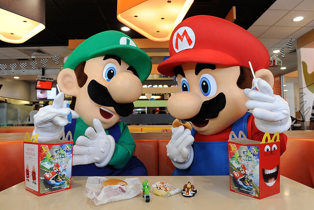 Nintendo characters Mario and Luigi enjoy Happy Meals on July 12, 2014 in Los Angeles, California. The fast-food chain is ditching plastic toys for more sustainable options