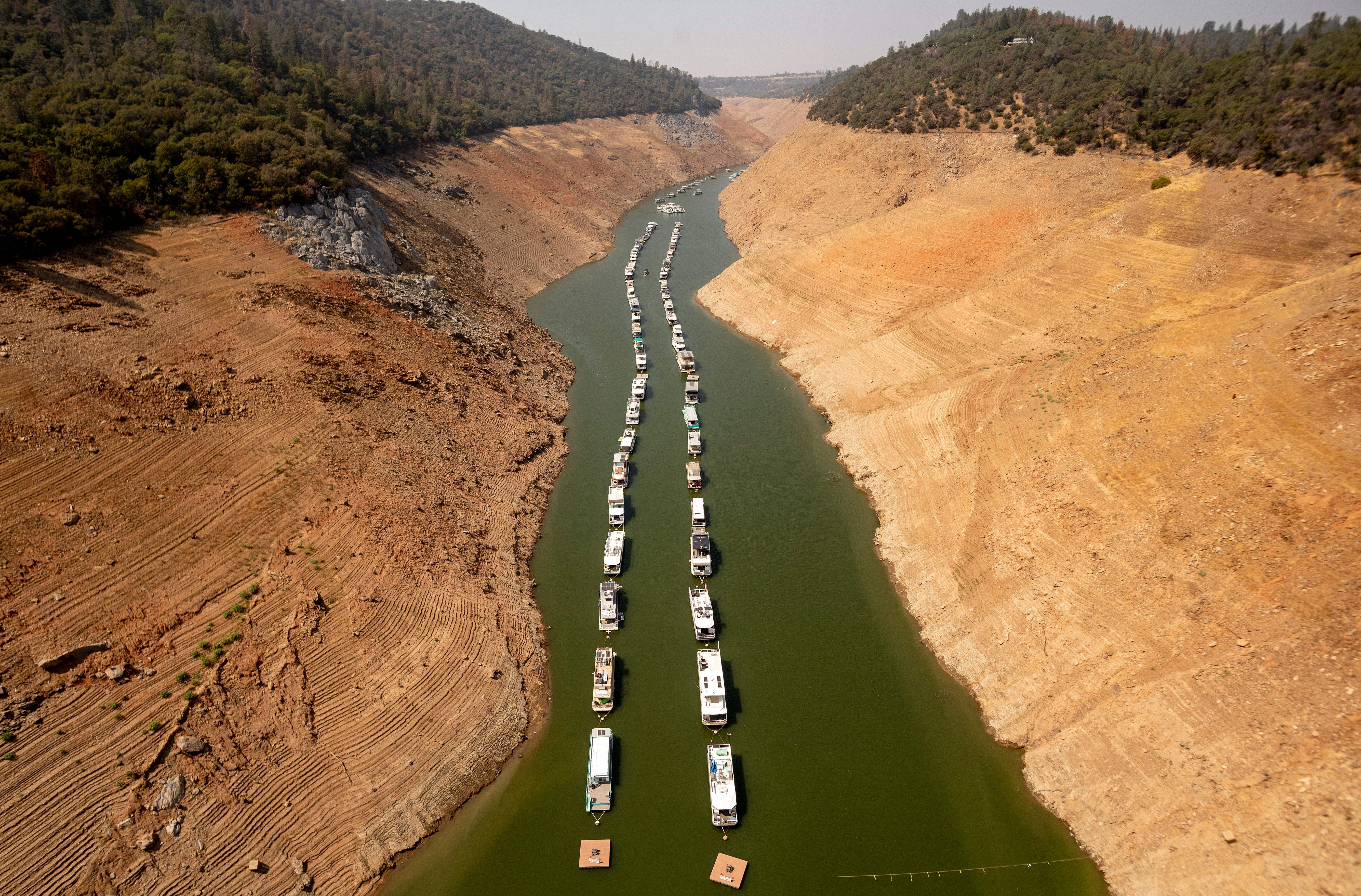 Houseboats sit in a narrow section of water in a depleted Lake Oroville in California, which is currently at 23% of its capacity, suffering from extreme levels of drought