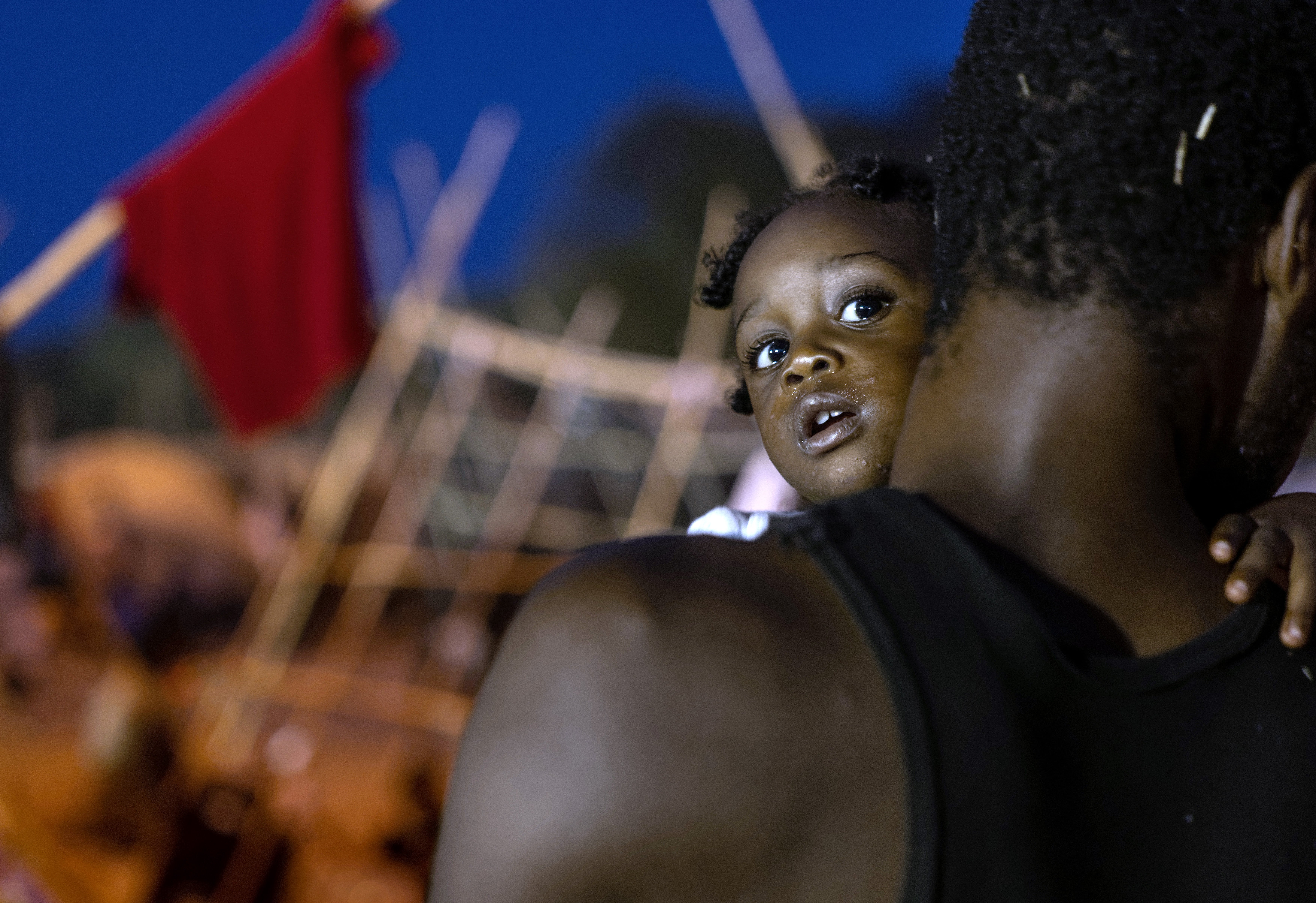 A father and daughter pass the evening inside a migrant camp at the US-Mexico border on 21 September 2021 in Del Rio, Texas