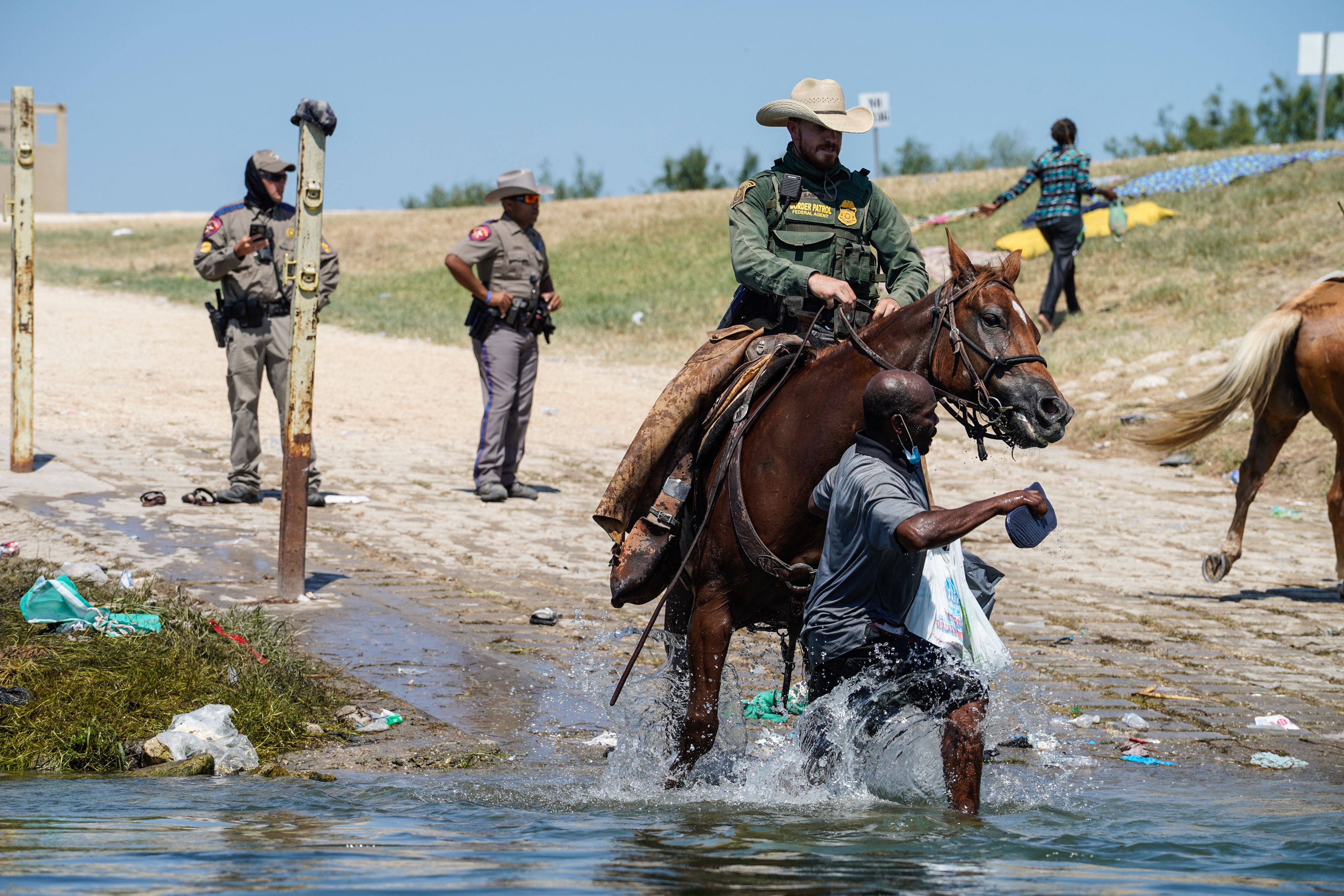 A United States Border Patrol agent on horseback tries to stop a Haitian migrant from entering an encampment on the banks of the Rio Grande near the Acuna Del Rio International Bridge in Del Rio, Texas on 19 September 2021