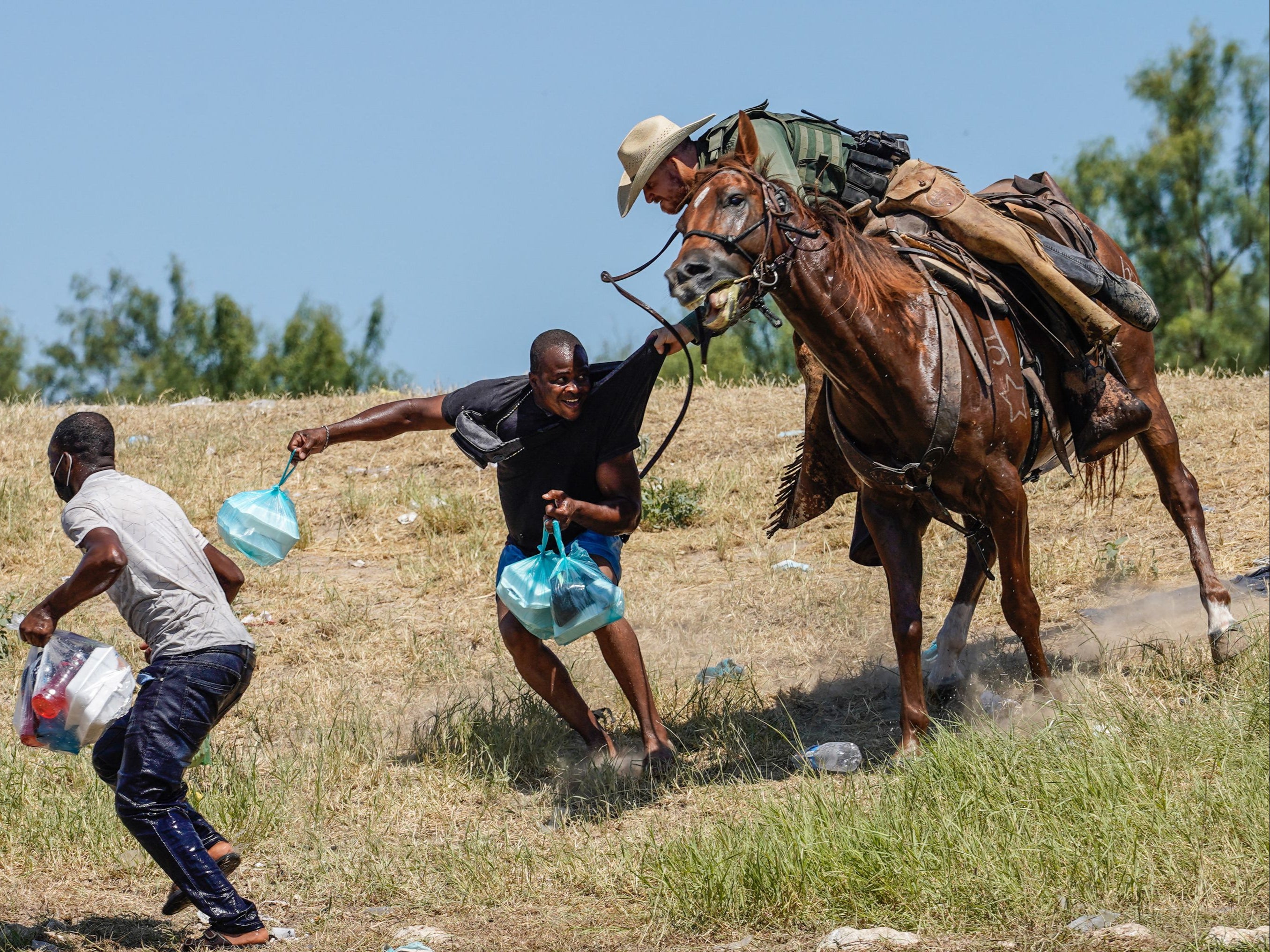 A United States Border Patrol agent on horseback tries to stop a Haitian migrant from entering an encampment on the banks of the Rio Grande near the Acuna Del Rio International Bridge in Del Rio, Texas, on 19 September