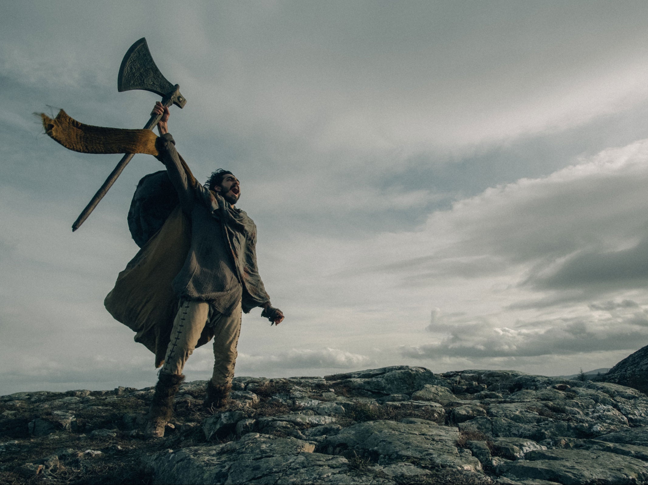 Gawain’s (Dev Patel) ochre-dyed cloak stands out beautifully against the film’s earthy, frost-bitten backdrops