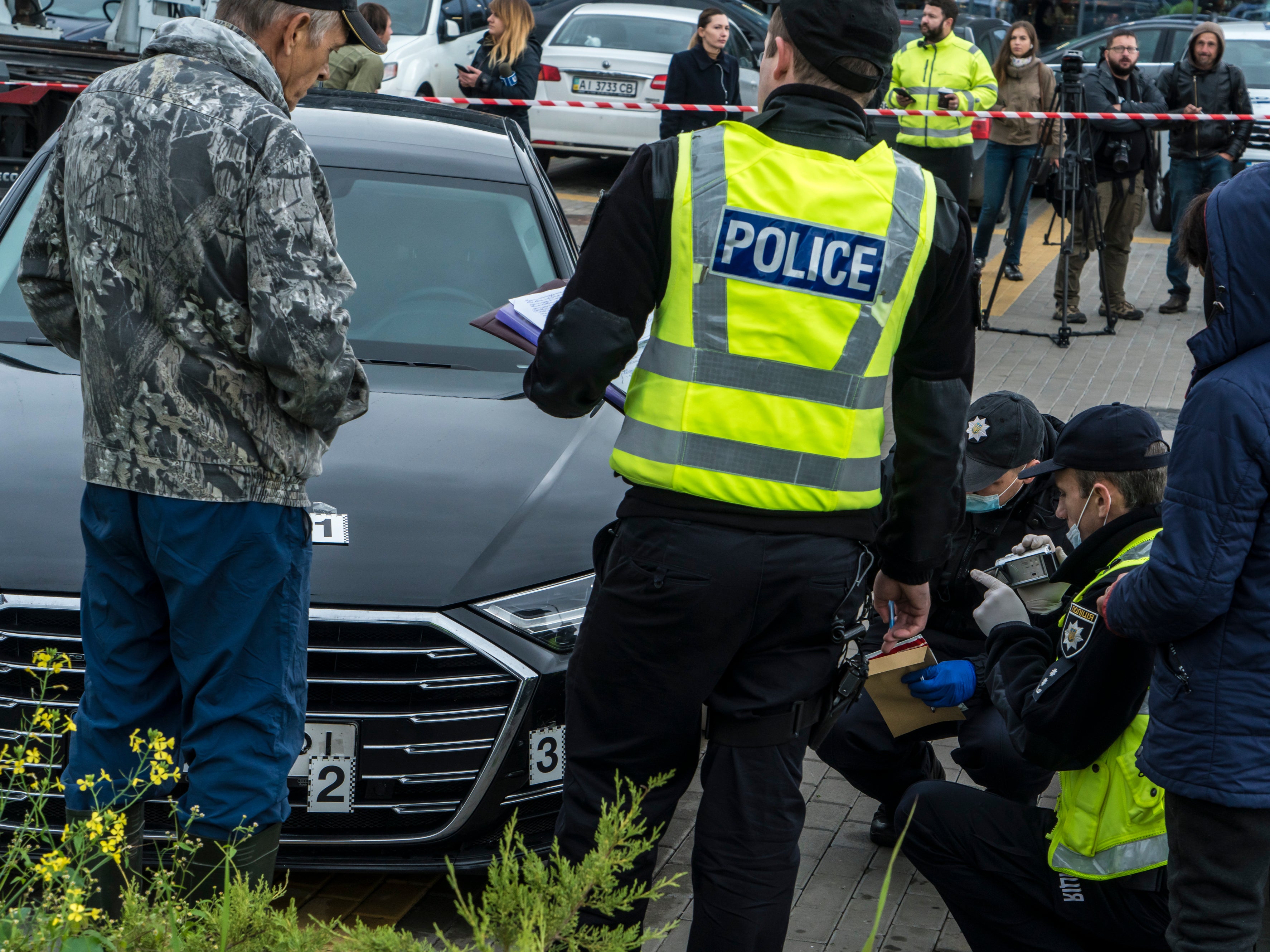 Police examine the car of Shefir on Wednesday after an apparent assassination attempt