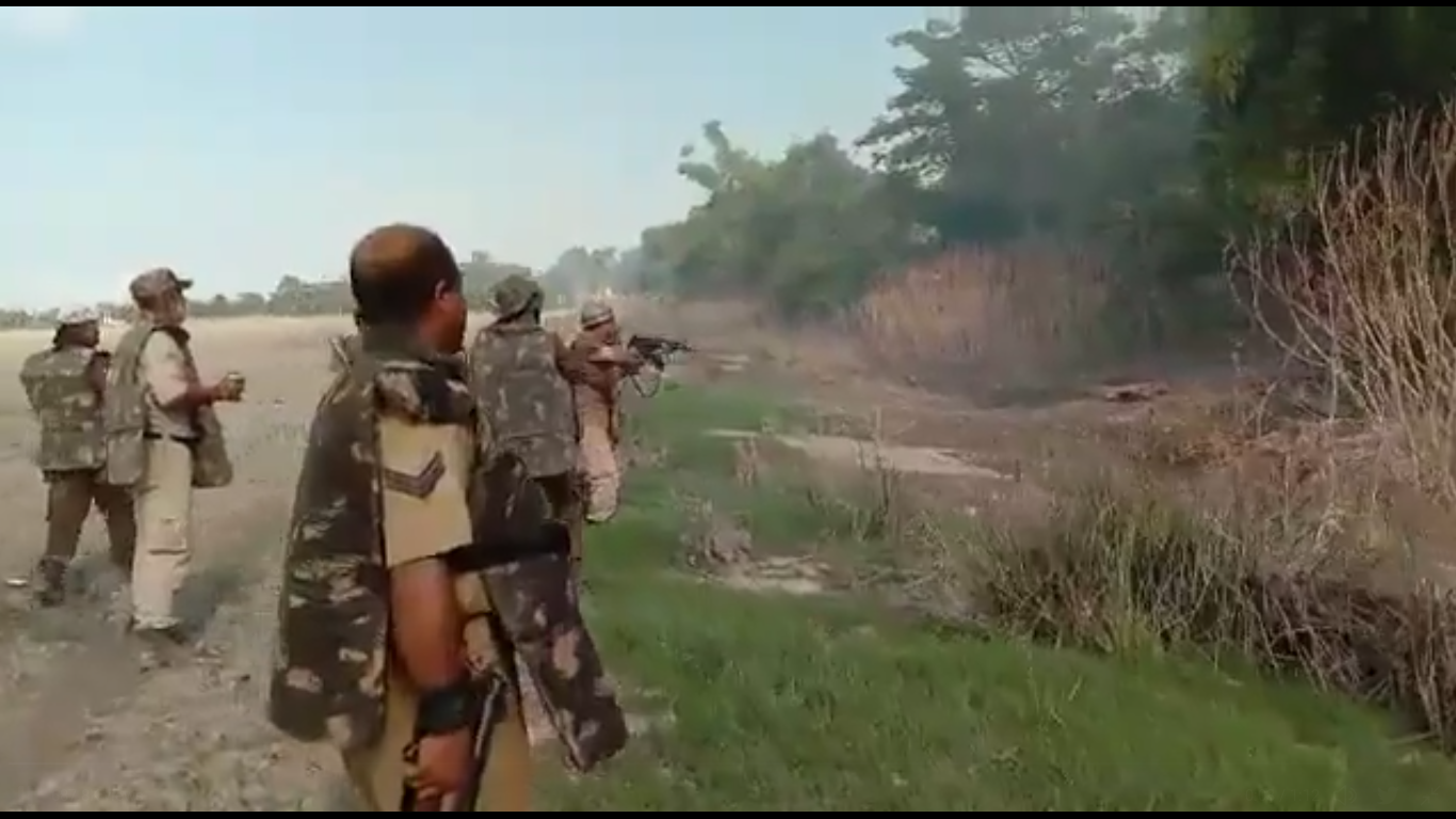 Screengrab from the video showing police in riot gear firing shots at targets from behind bushes