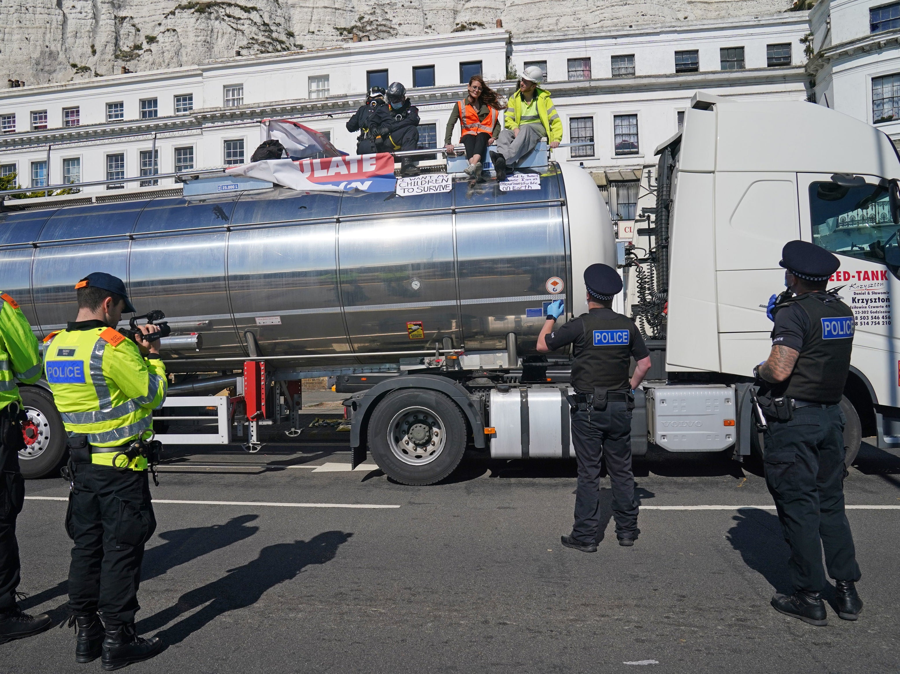Police officers remove two Insulate Britain protesters from the top of a tanker at the Port of Dover after the glue themselves to vehicle