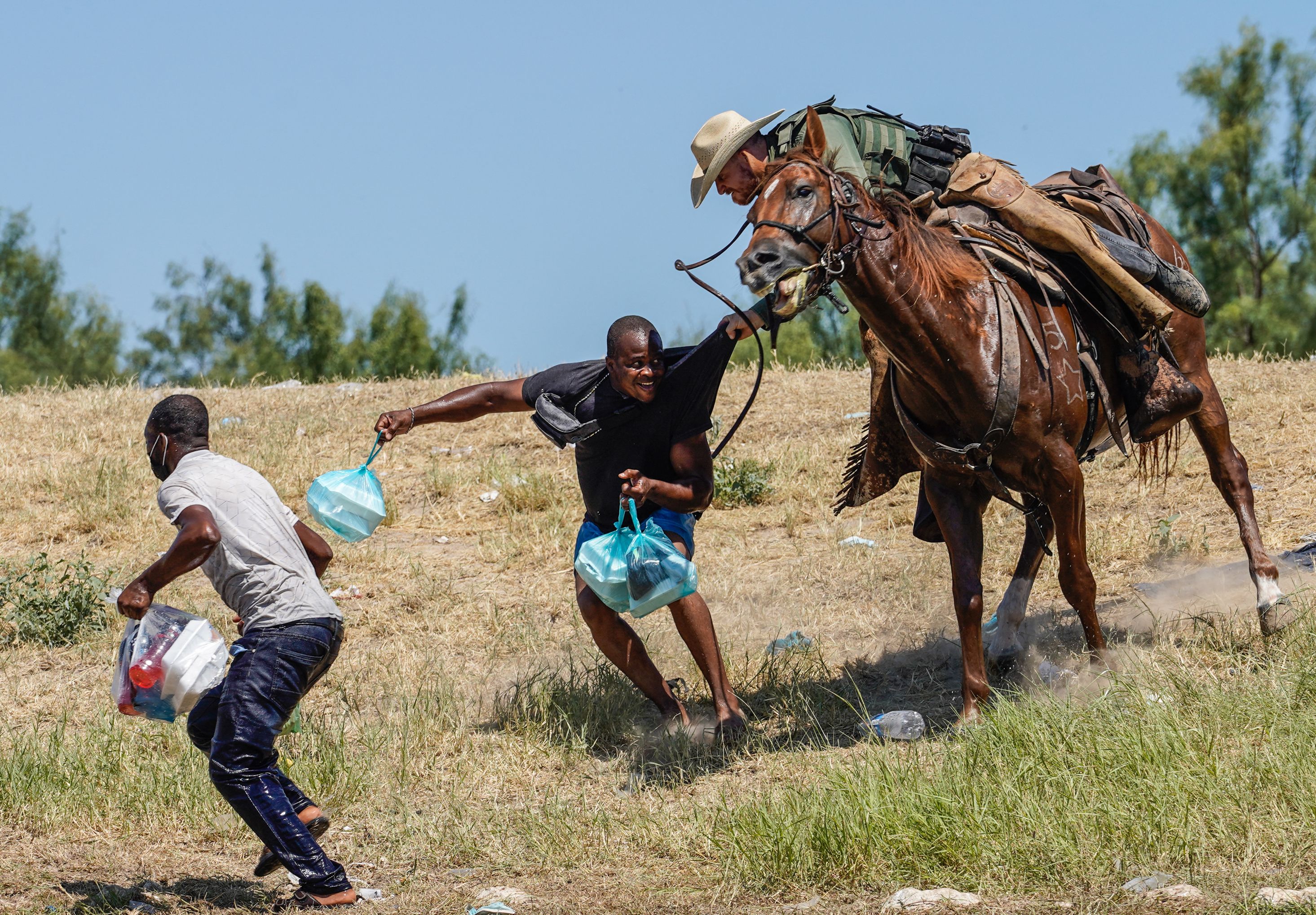 A US border patrol officer corrals a Haitian migrant earlier in September