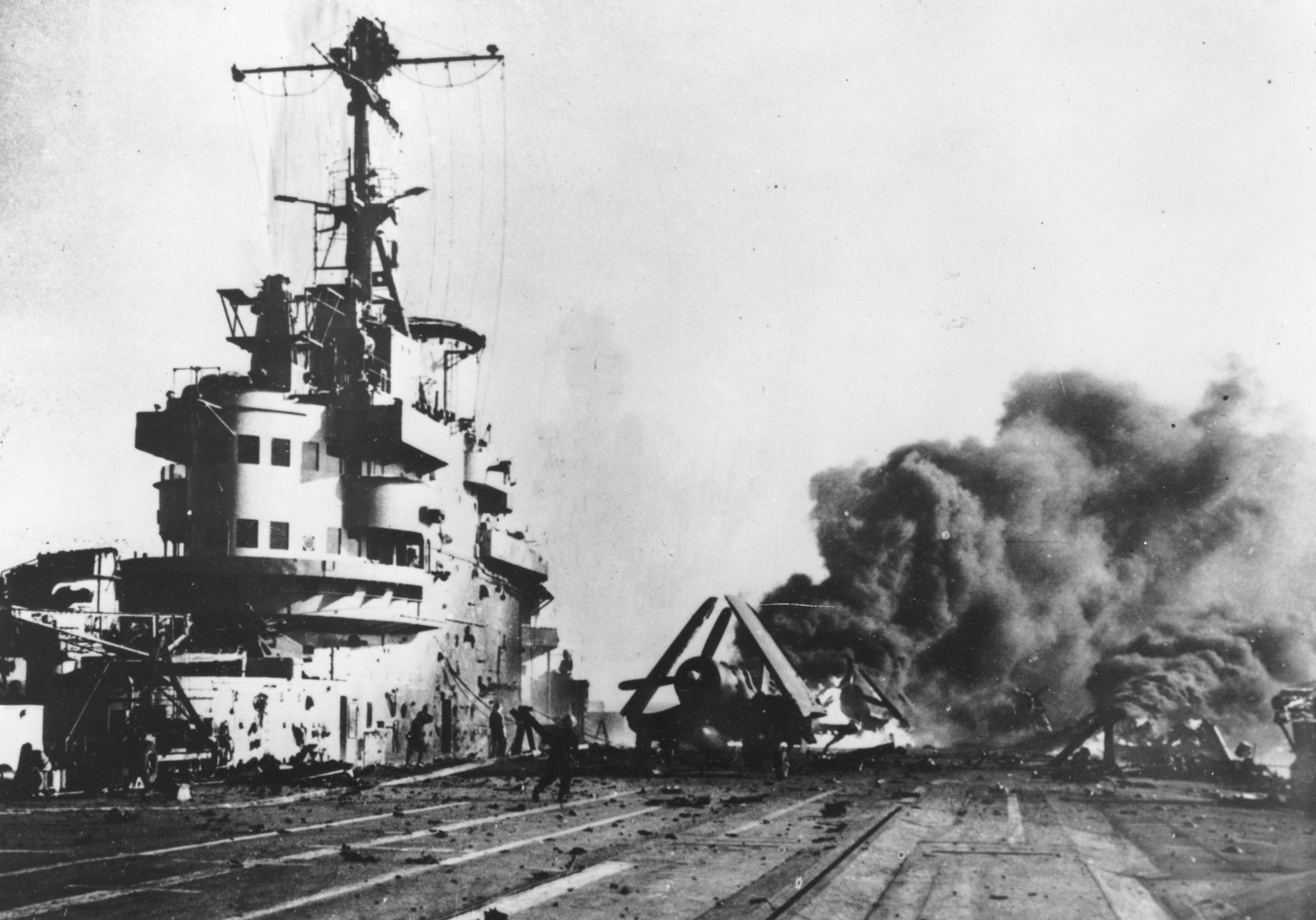 Circa 1944: a Japanese kamikaze plane burning on the deck of an allied aircraft carrier