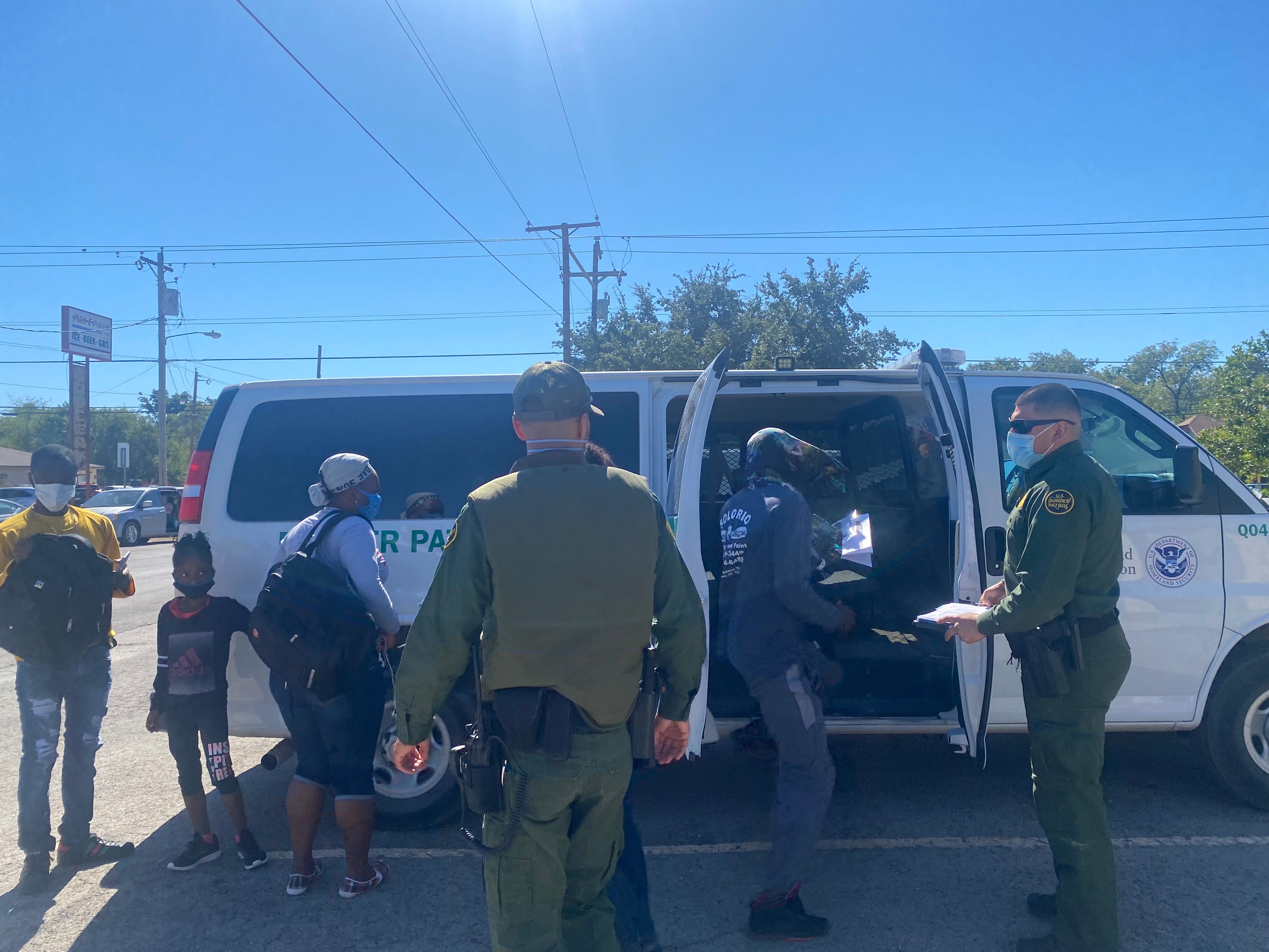 A border patrol bus drops off migrants at a transfer centre in Del Rio