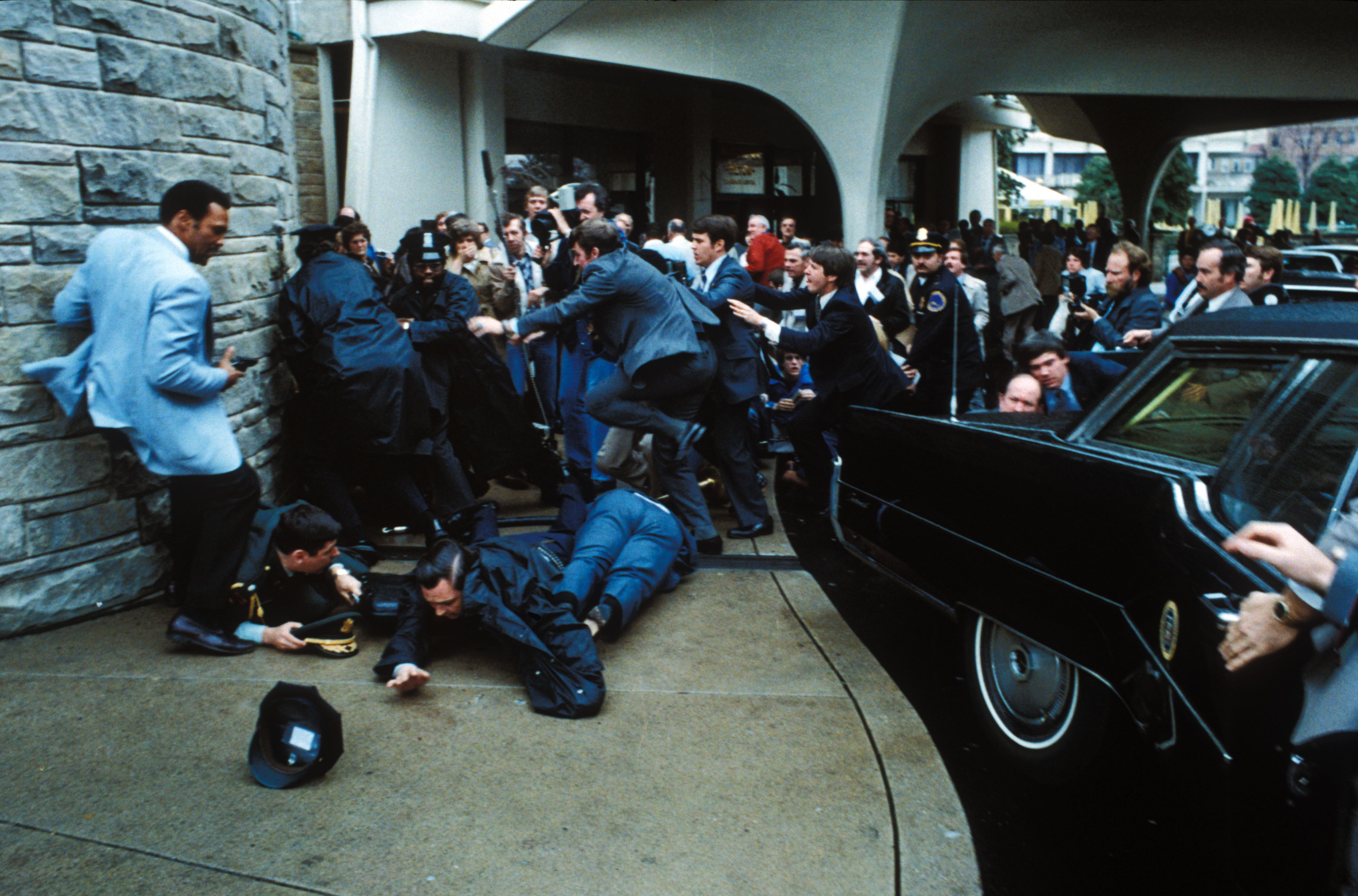 Secret Service agents pounce on John Hinckley Jnr while Press Secretary James Brady, Patrolman Thomas Delahanty and Secret Service Agent Timothy Mccarty lie injured on the ground